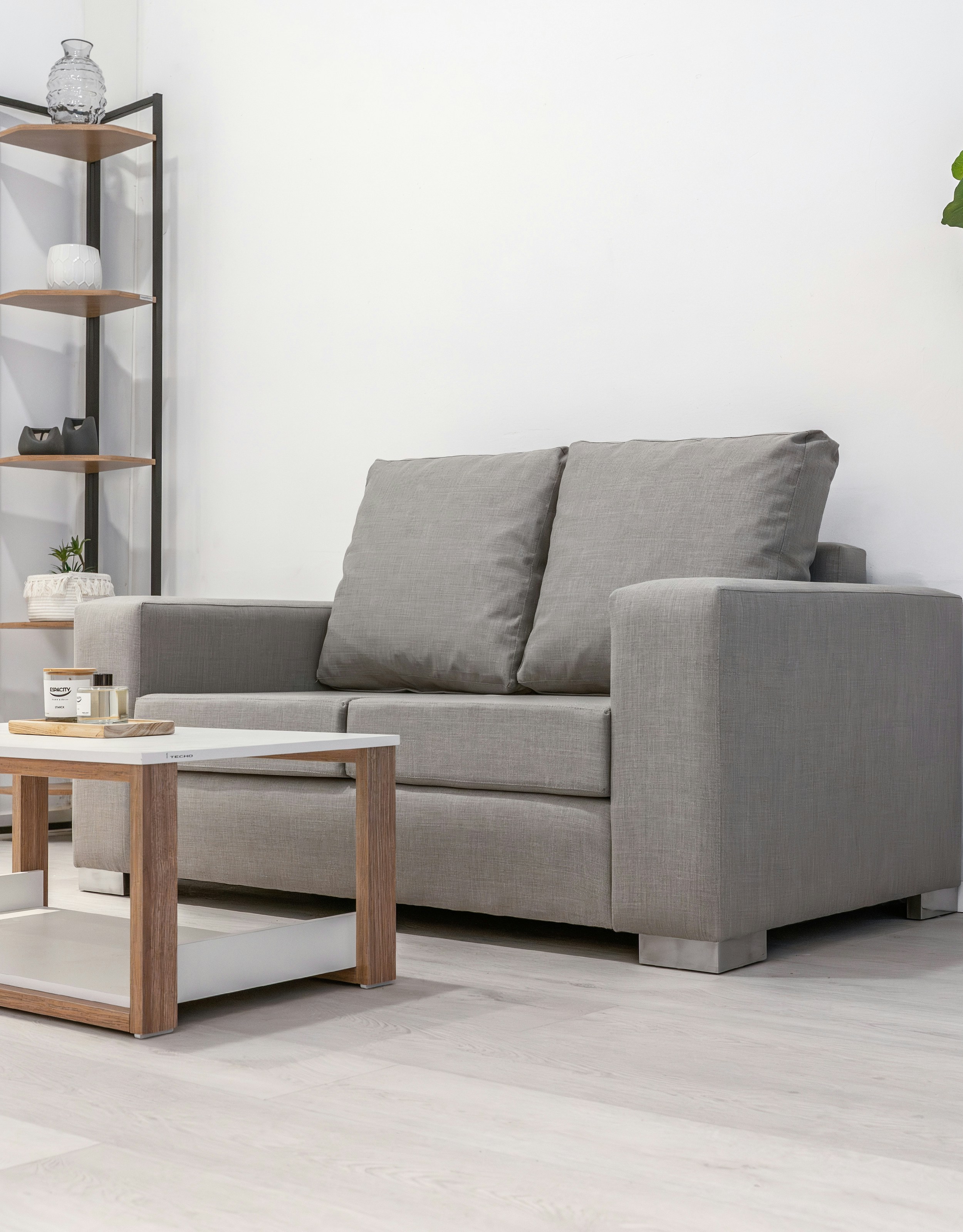 A gray loveseat and coffee table in a room.