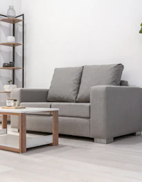 A gray loveseat and coffee table in a room.
