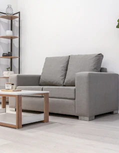 A gray loveseat and coffee table in a room.