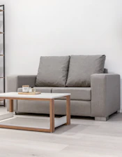 A gray sofa with a modern coffee table.