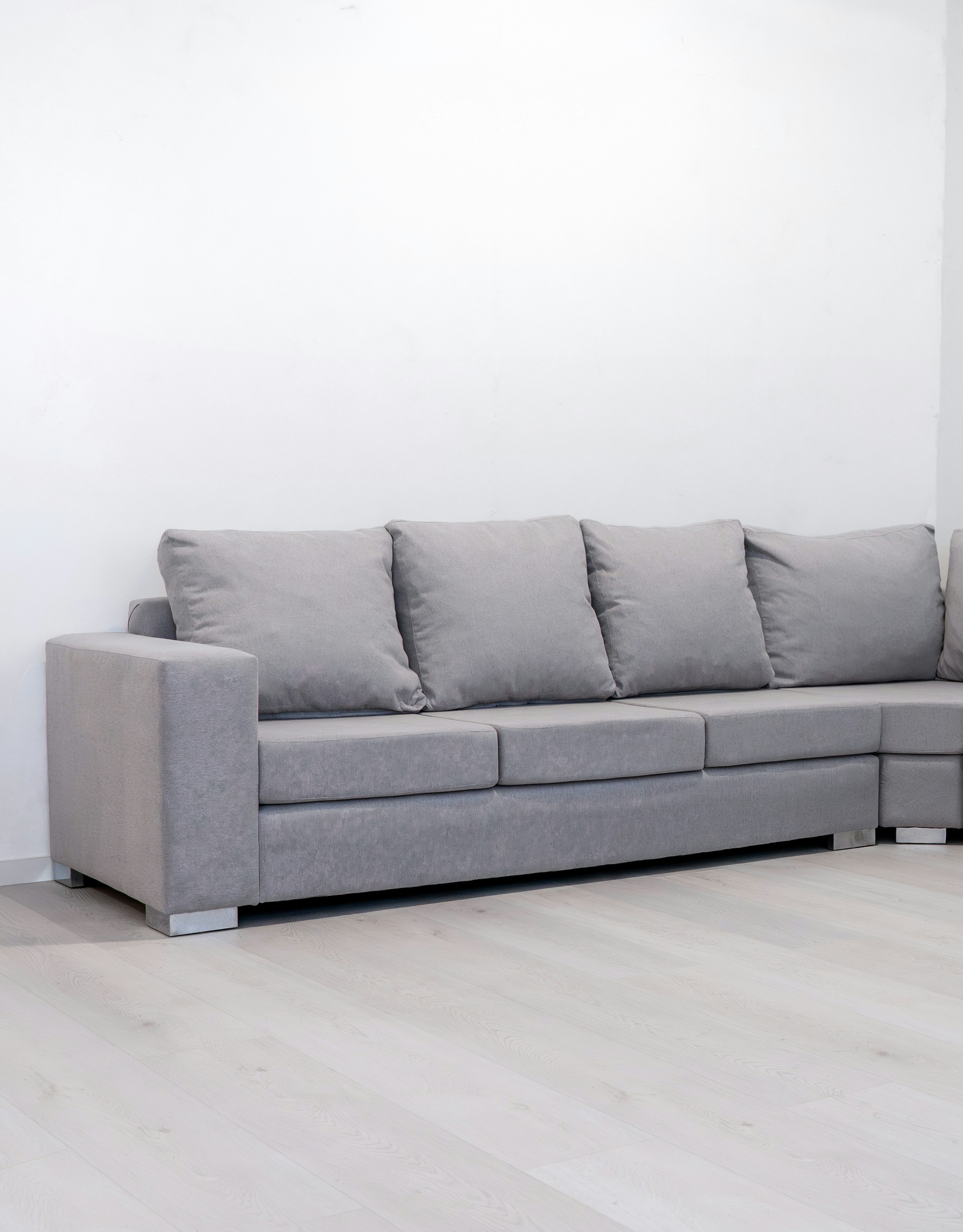 A modern grey sectional sofa against a white wall.