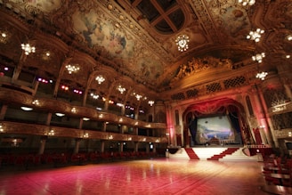 Ornate ballroom with stage and tiered seating