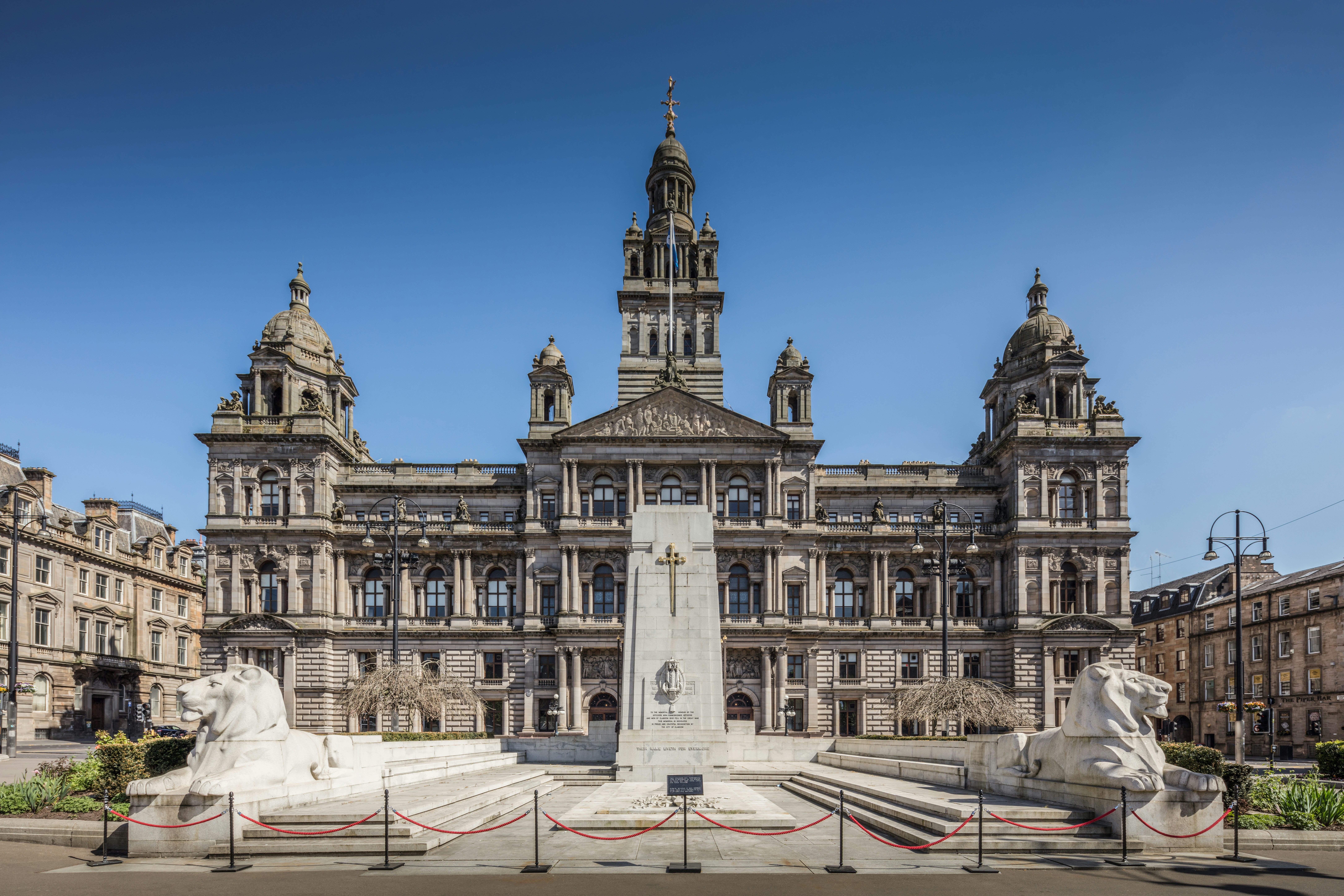 Grand historic building with a monument outside.