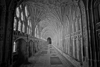Ornate gothic hallway with arched windows and vaulted ceiling