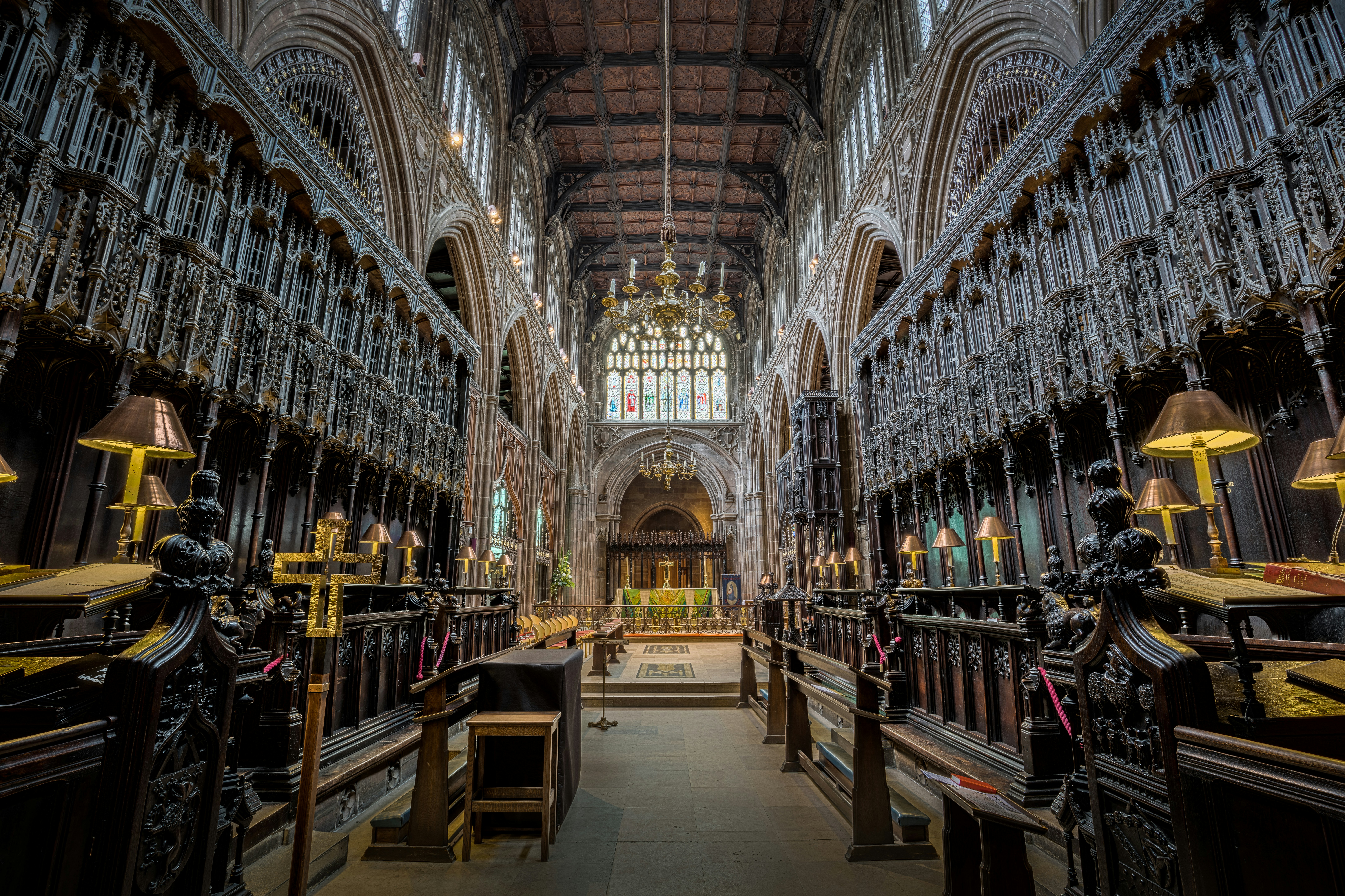 Ornate wooden pews and carvings inside a grand cathedral.