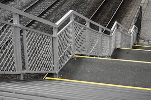 Stairs with metal railing beside train tracks