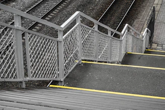 Stairs with metal railing beside train tracks