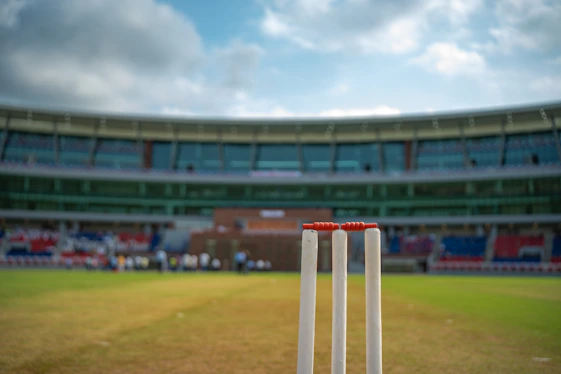 Cricket stumps on a grassy field at stadium