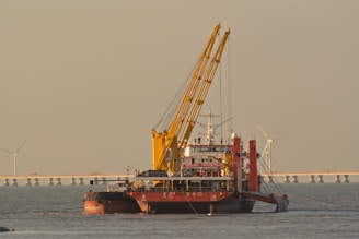 A large dredging vessel with cranes on the water.
