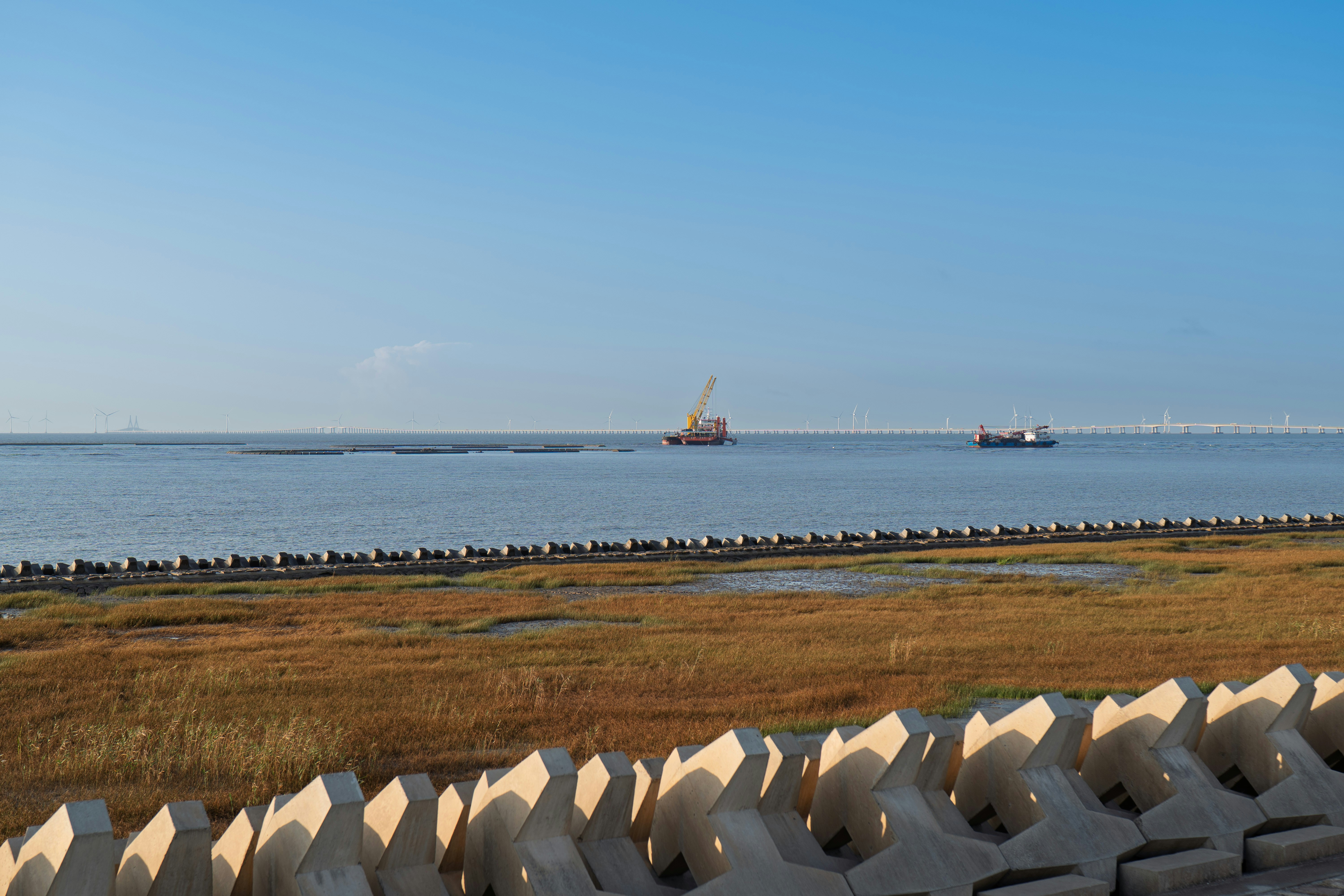 Boats on the ocean near a breakwater
