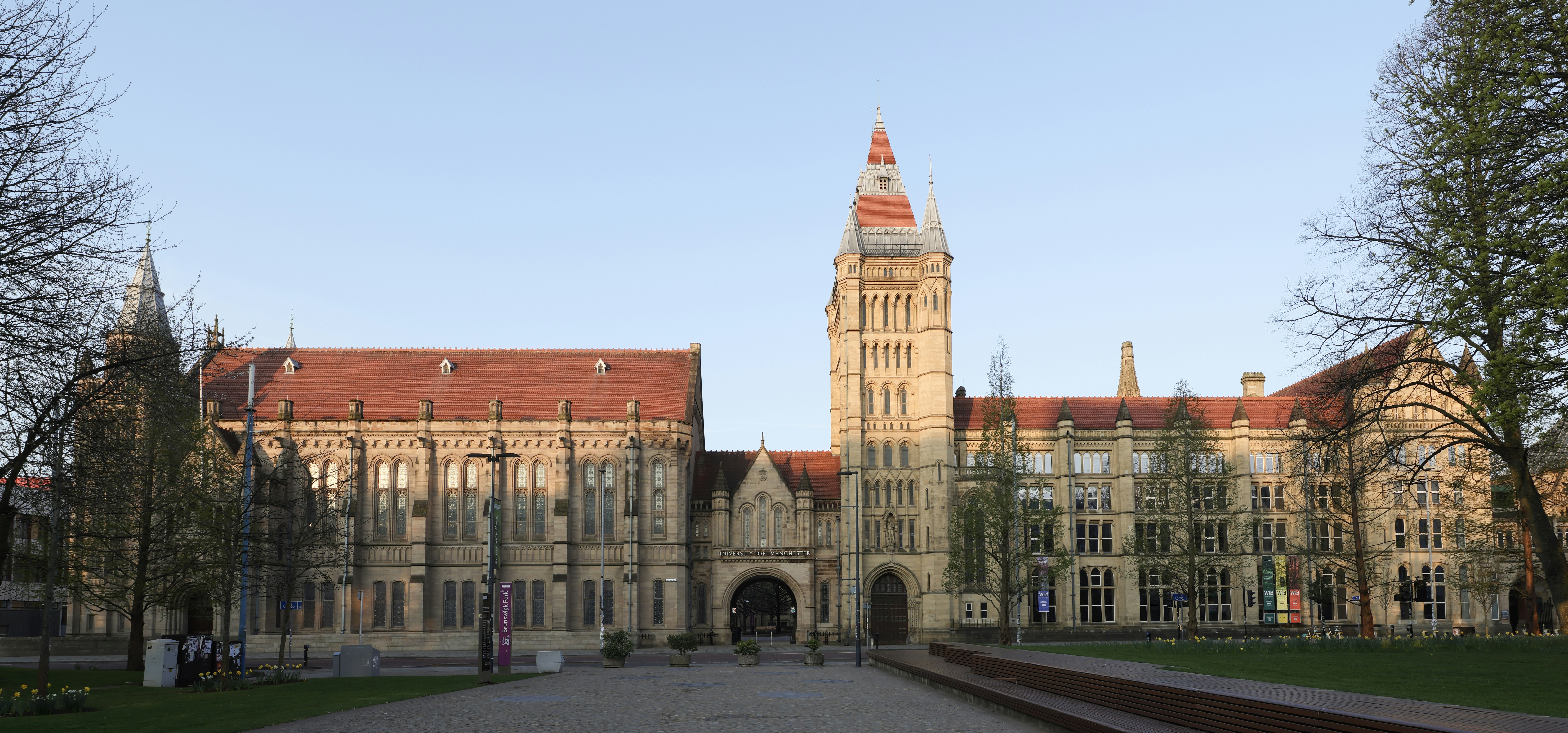 Large stone building with a tall tower and red roof.