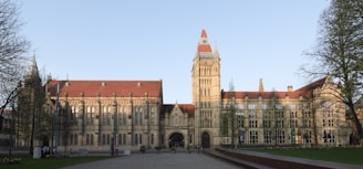Large stone building with a tall tower and red roof.
