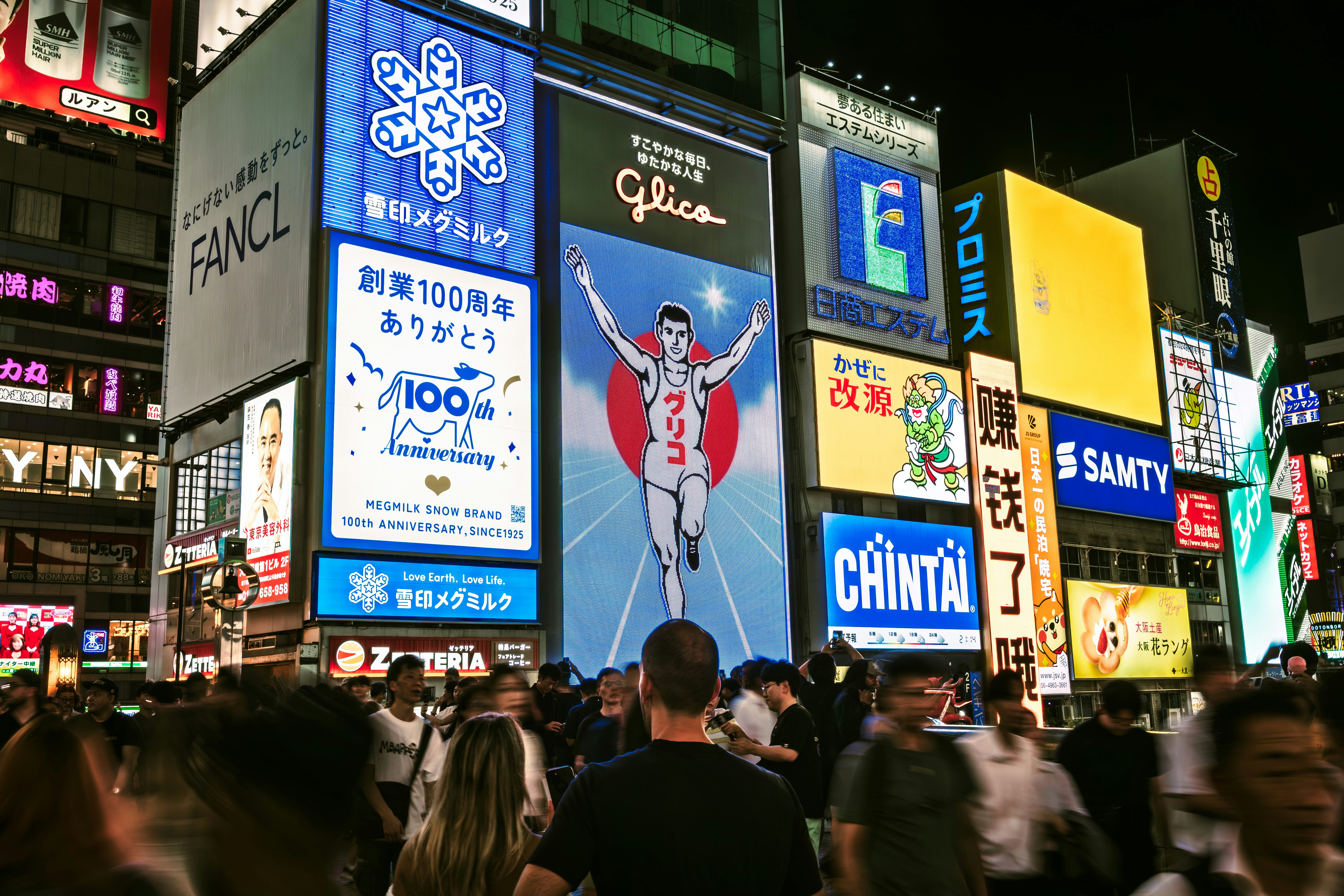 Crowded street with bright neon signs at night