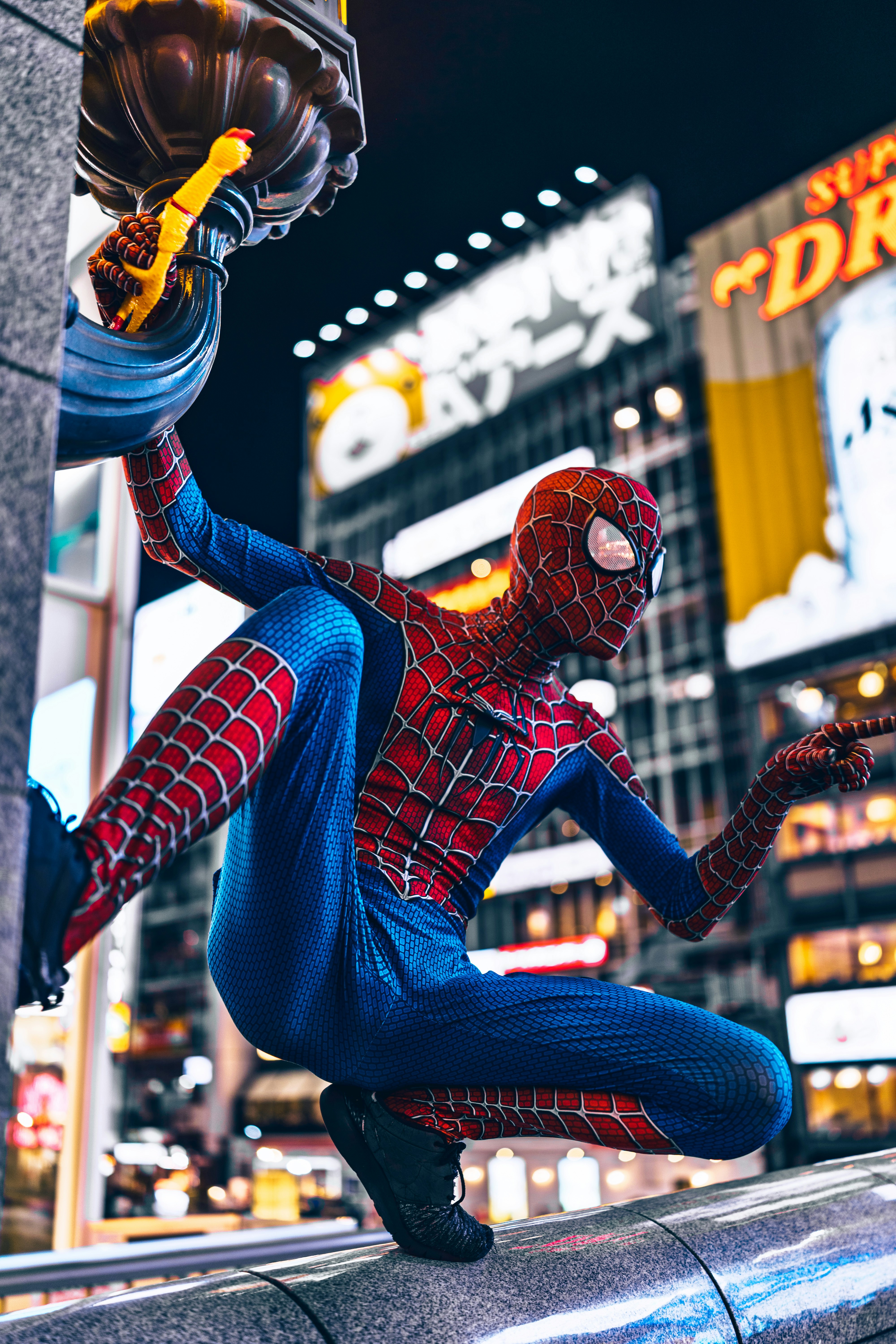 Spider-man berpose di langkan di malam hari.