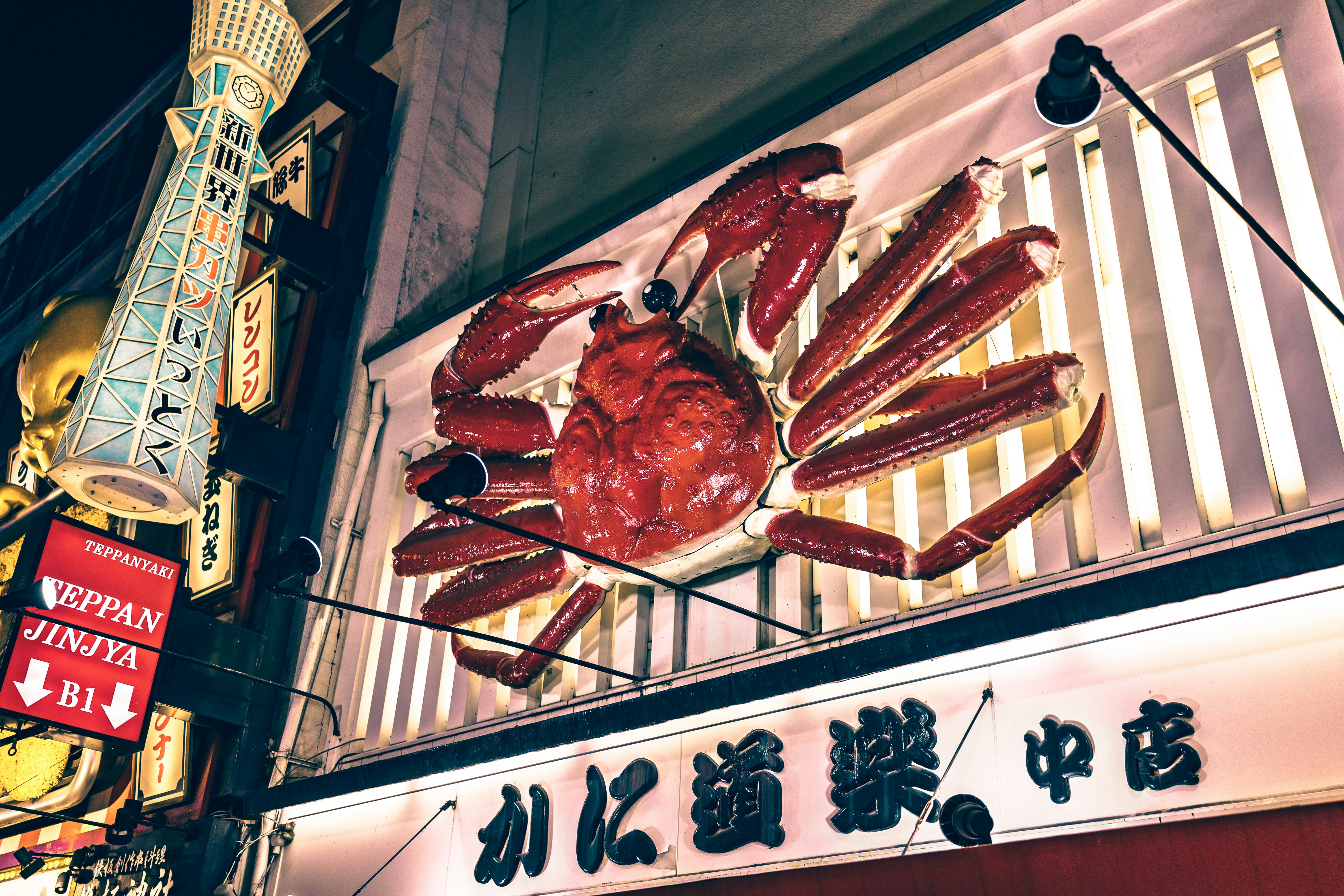Giant illuminated crab sign on a building at night.