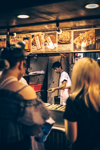 Vendor preparing food at a busy street stall