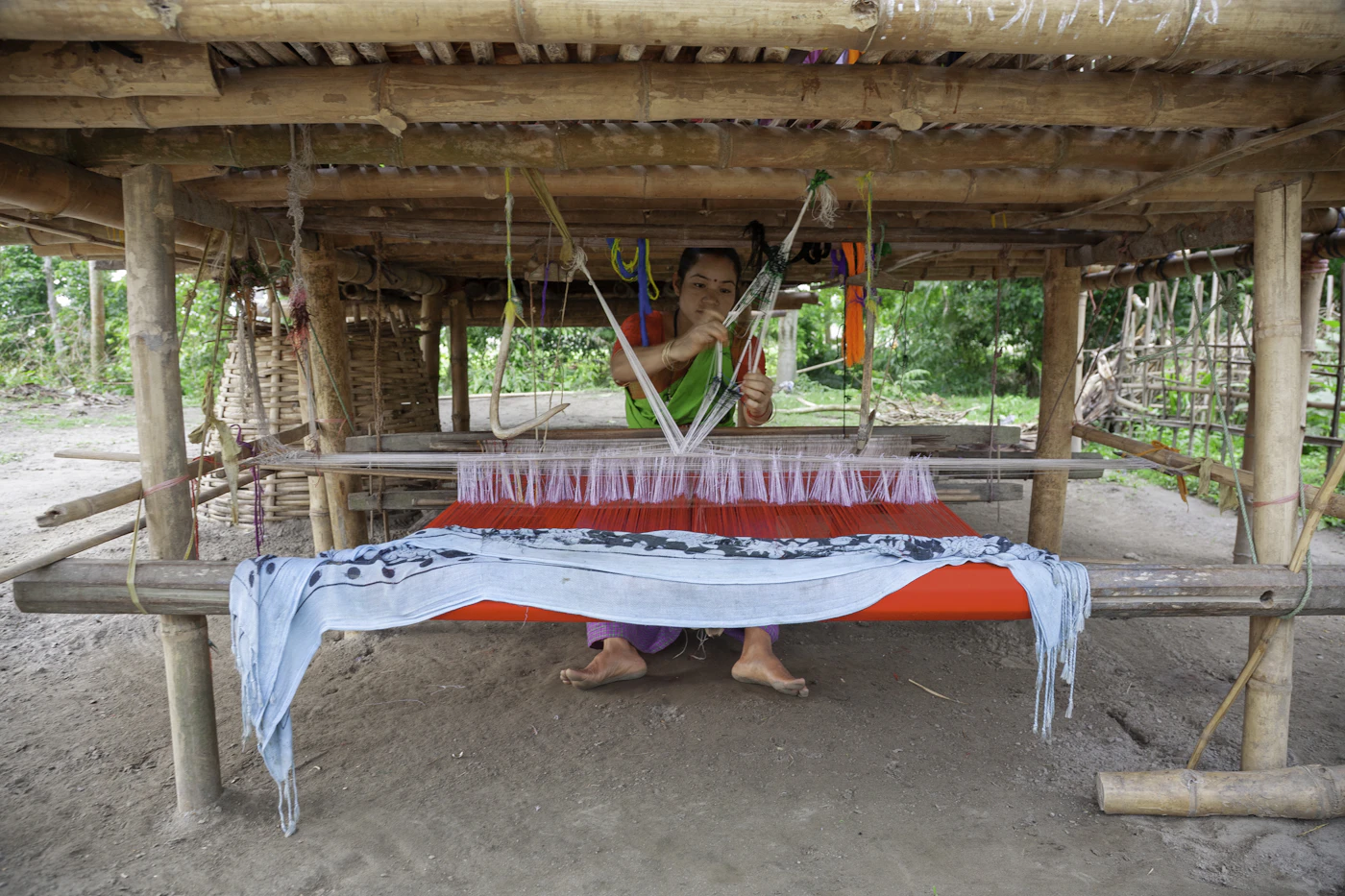 Artisan hand-weaving traditional cloth on a wooden loom