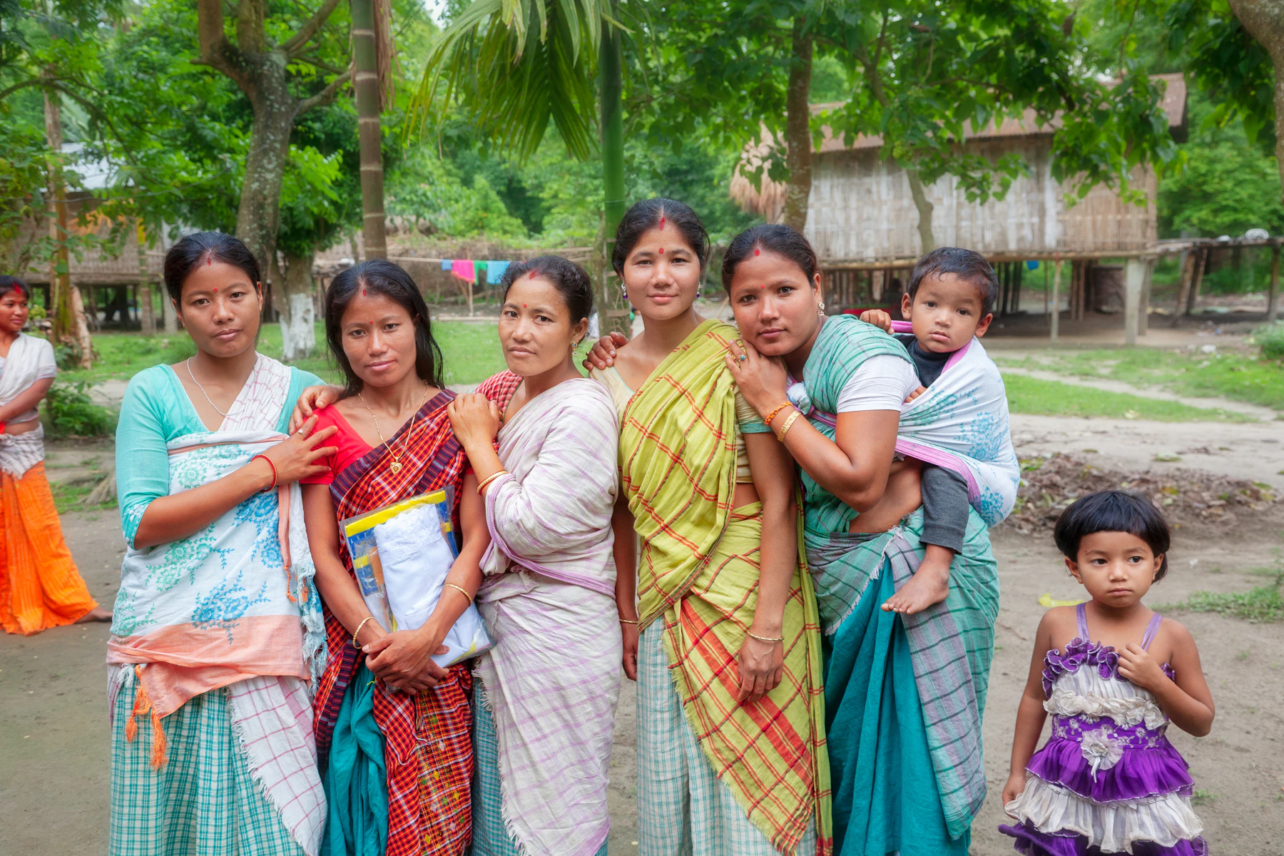 Women and children gathered together in a rural Indian village setting