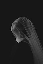 Woman's face covered with sheer fabric