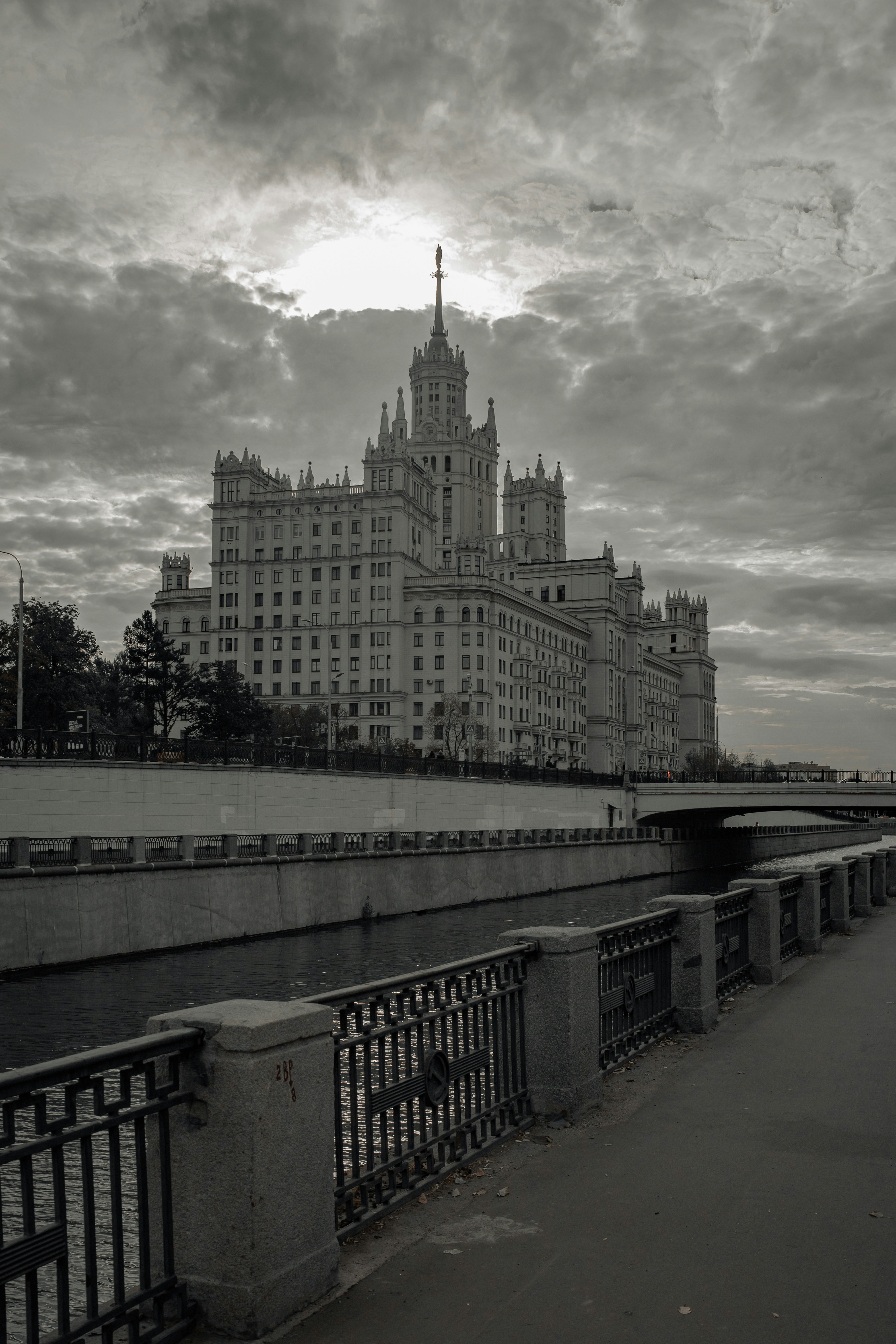 Grand building beside river under cloudy sky