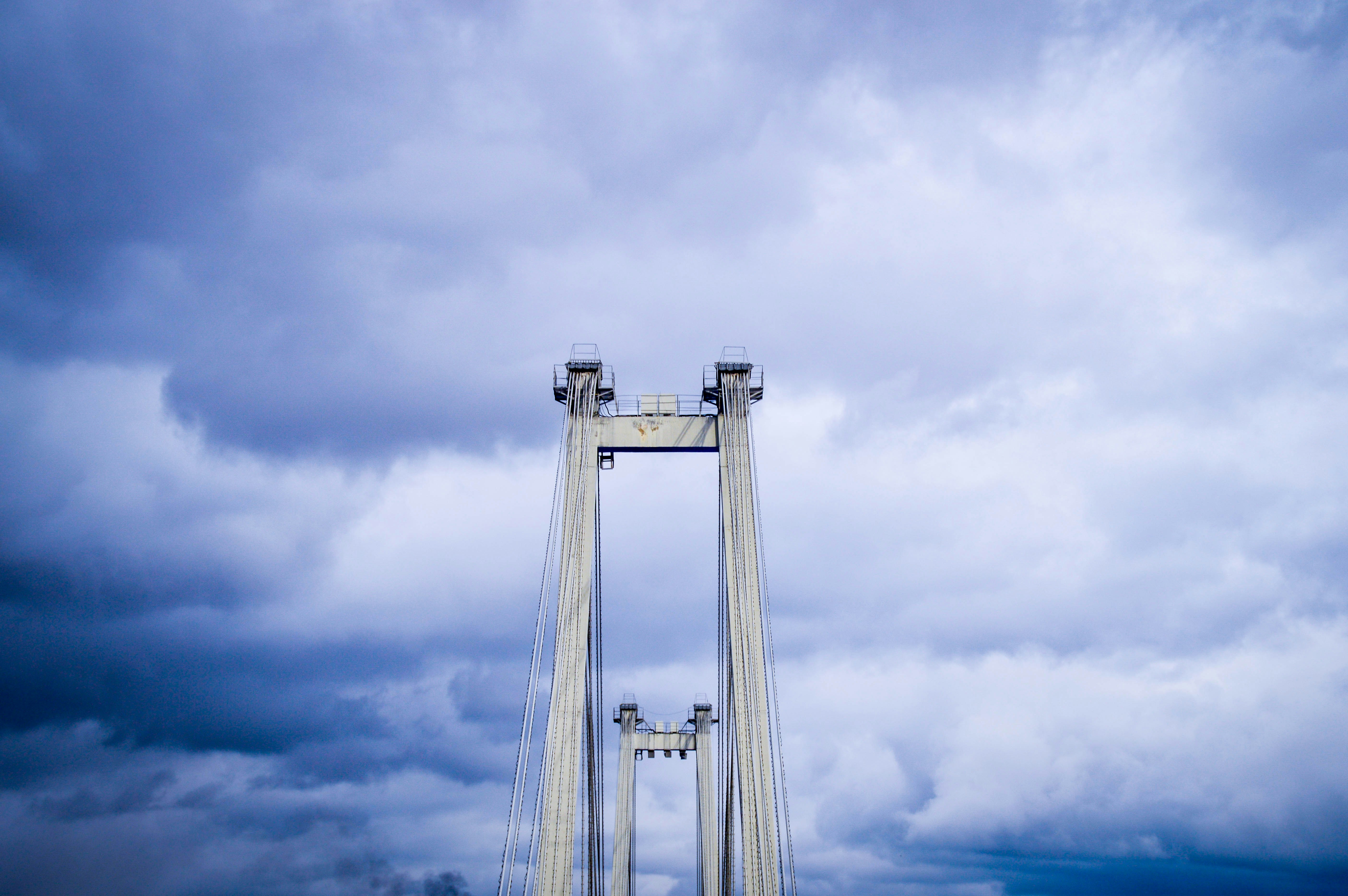 Concrete bridge towers against a cloudy sky