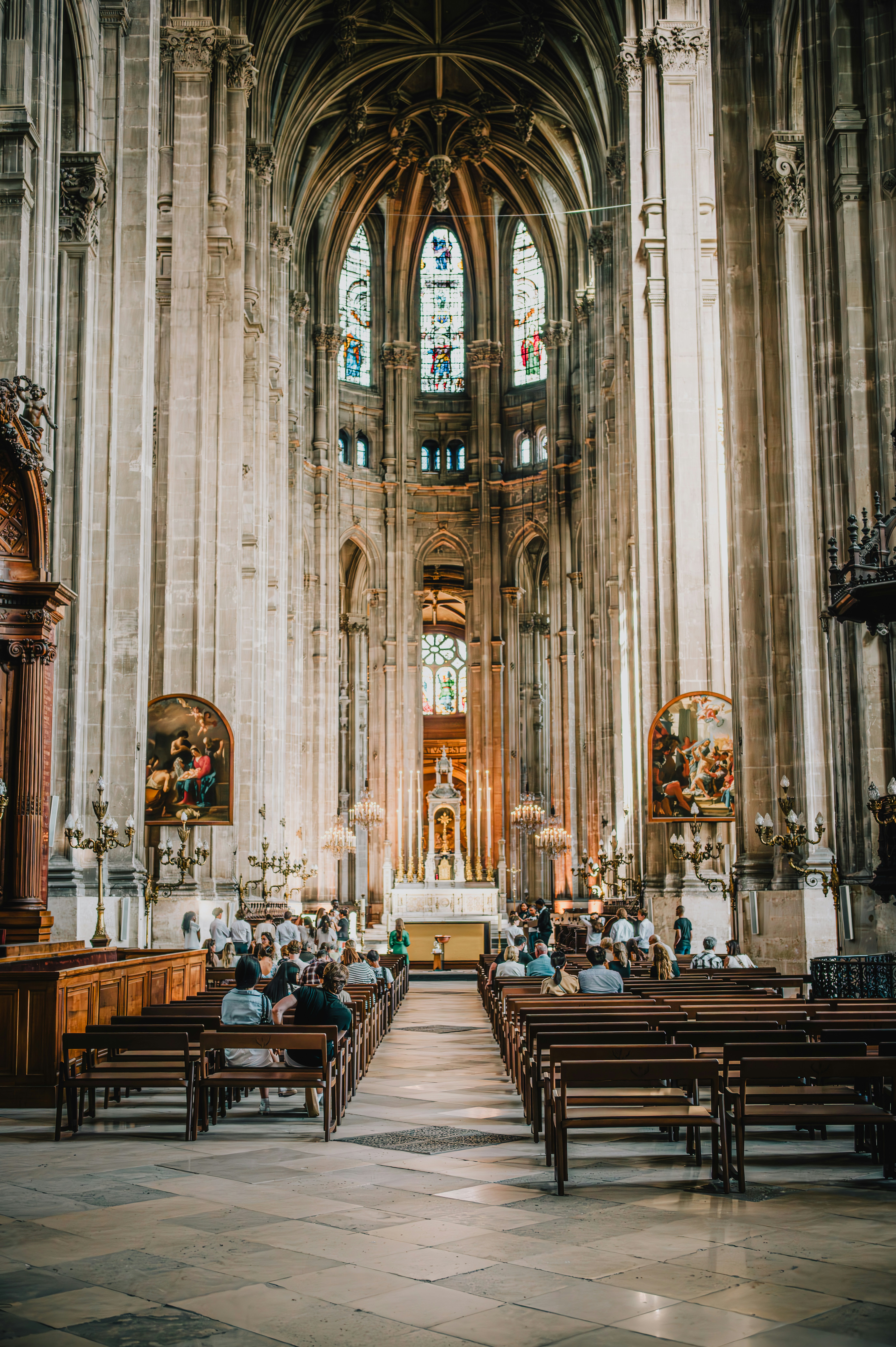 People sitting in a grand cathedral with tall arches.
