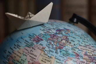 Origami boat sailing on a globe