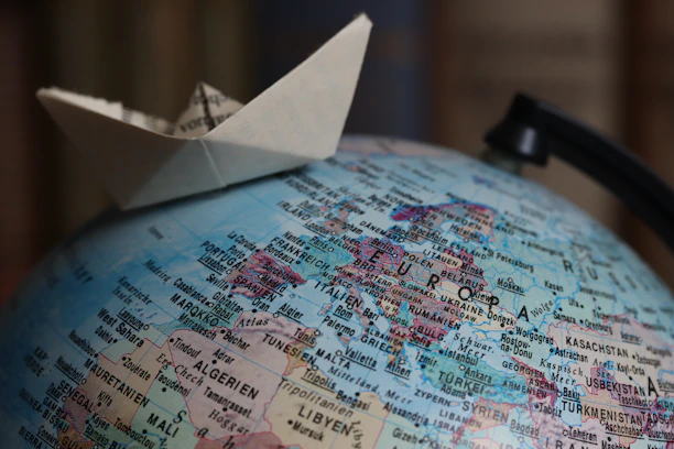 Origami boat sailing on a globe
