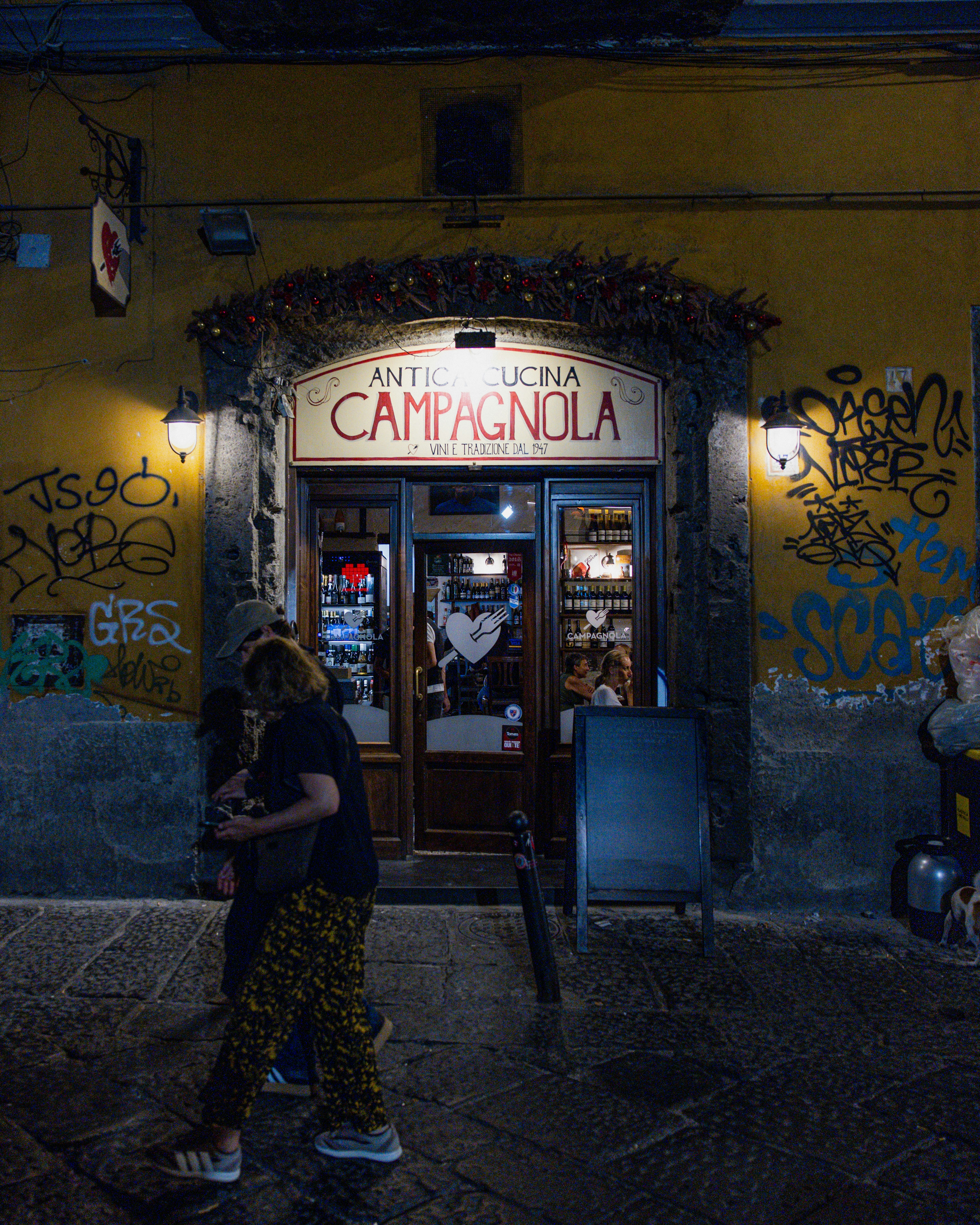 Restaurant entrance at night with graffiti