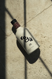 A bottle of roda olive oil on a stone surface.