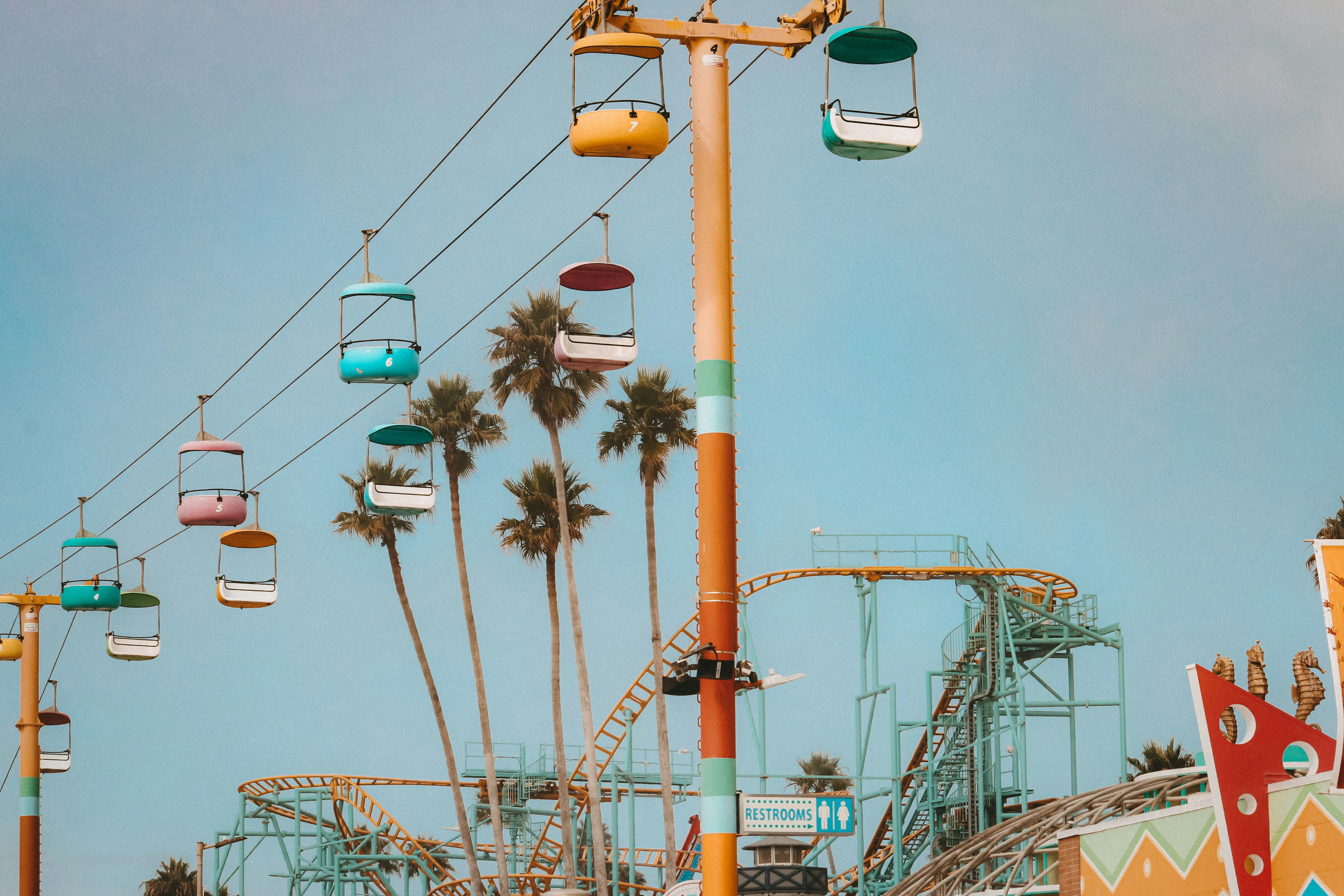 Colorful gondolas ascend against a bright sky.