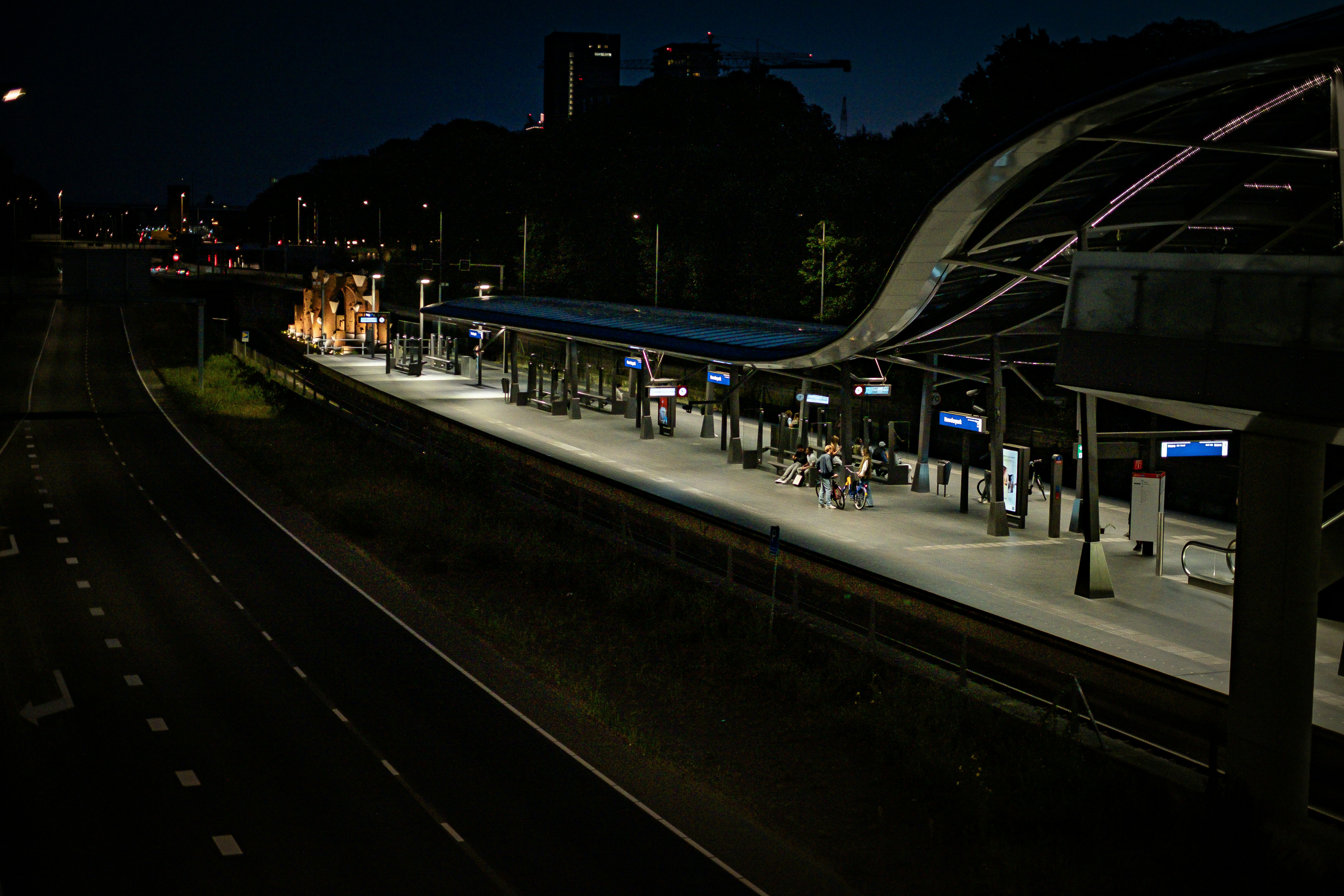 Plataforma de la estación de tren por la noche con luces encendidas