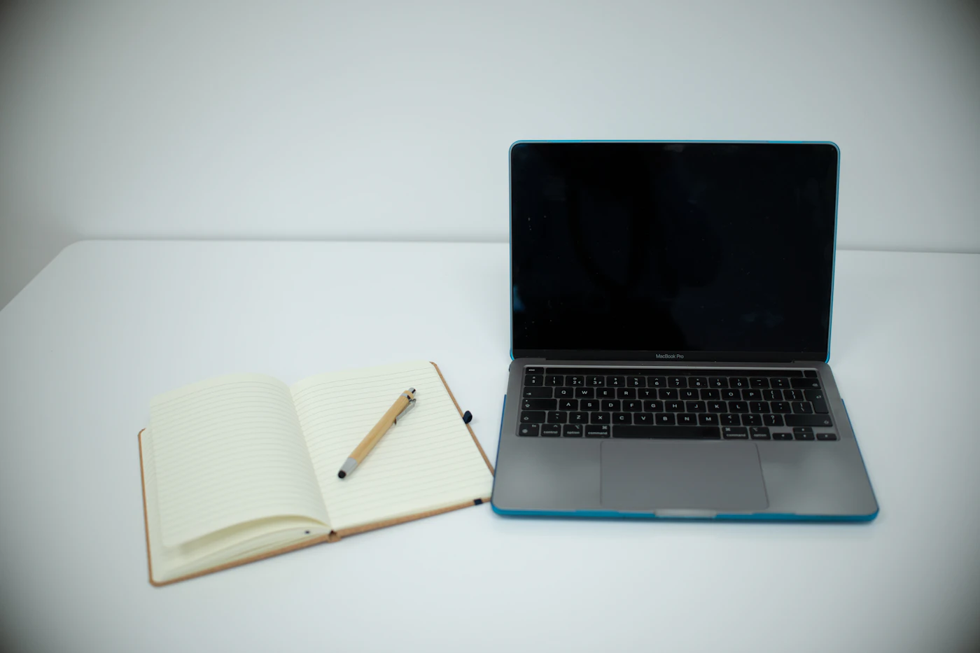 Laptop and open notebook used to plan a freelance writing project