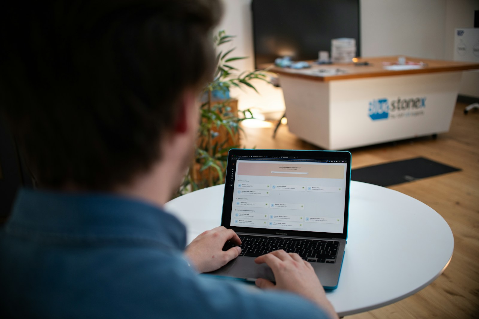 Person typing on a laptop at a white table
