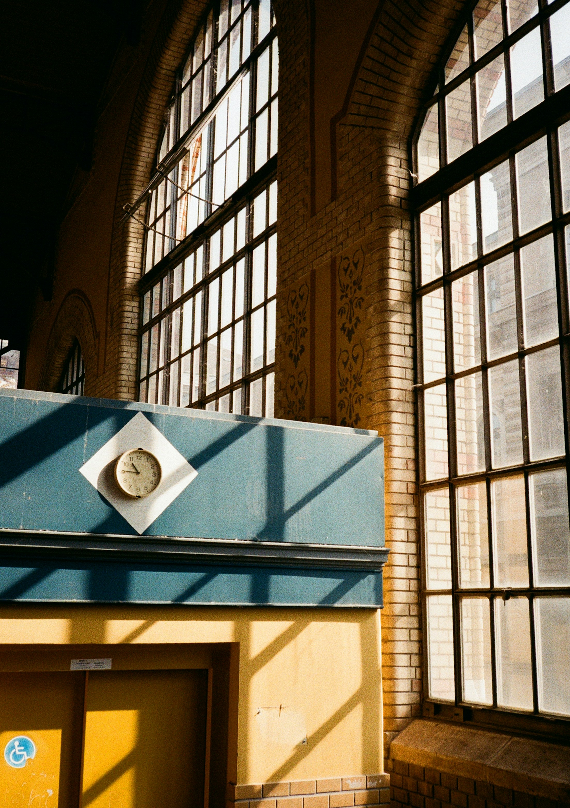 Large arched windows with sunlight casting shadows indoors