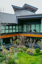 Modern building with a courtyard garden and people on balcony.