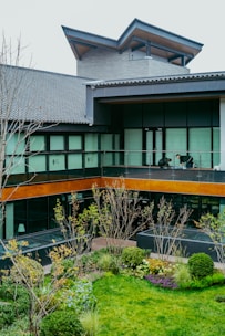 Modern building with a courtyard garden and people on balcony.