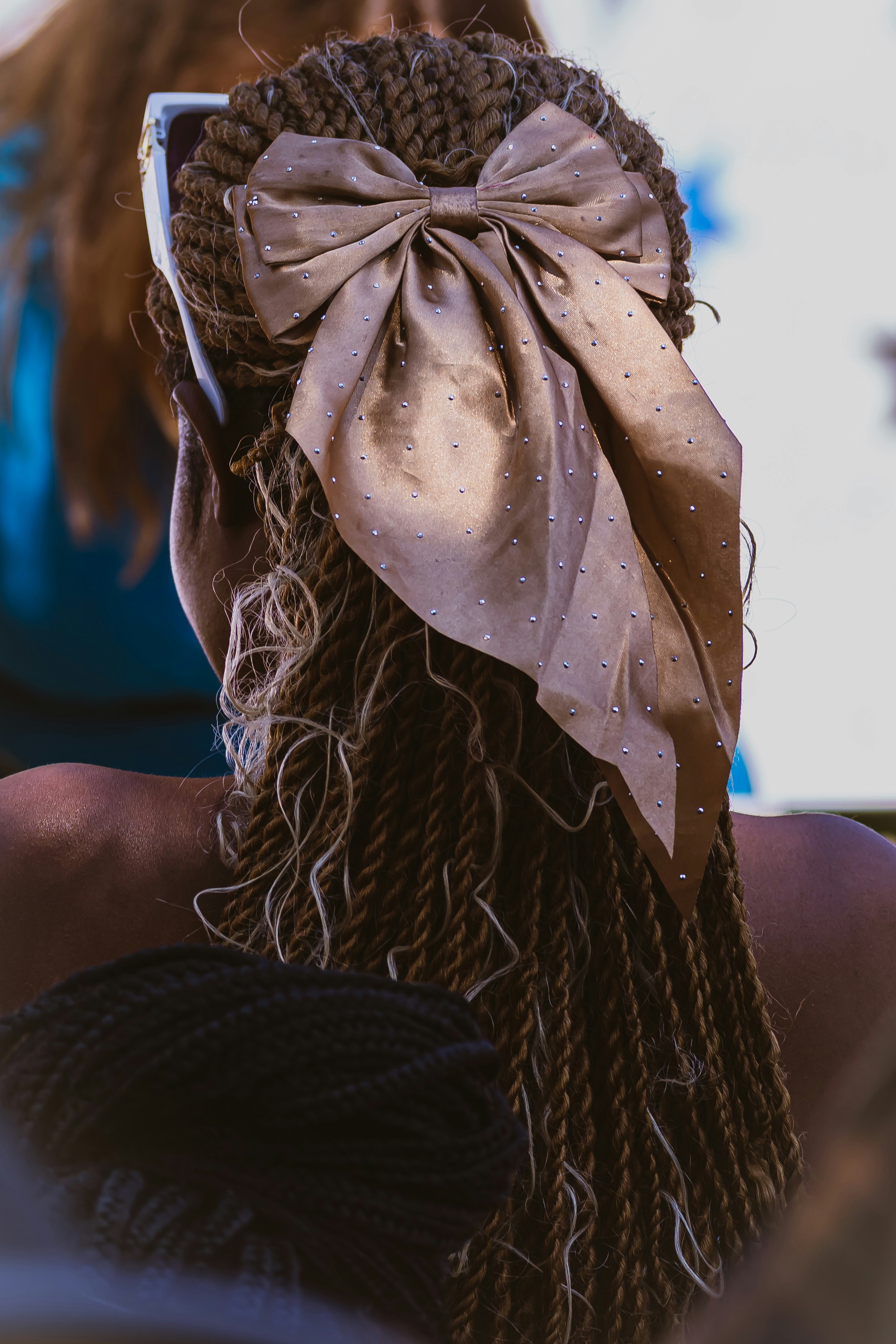 Woman with braided hair and a large bow accessory bow
