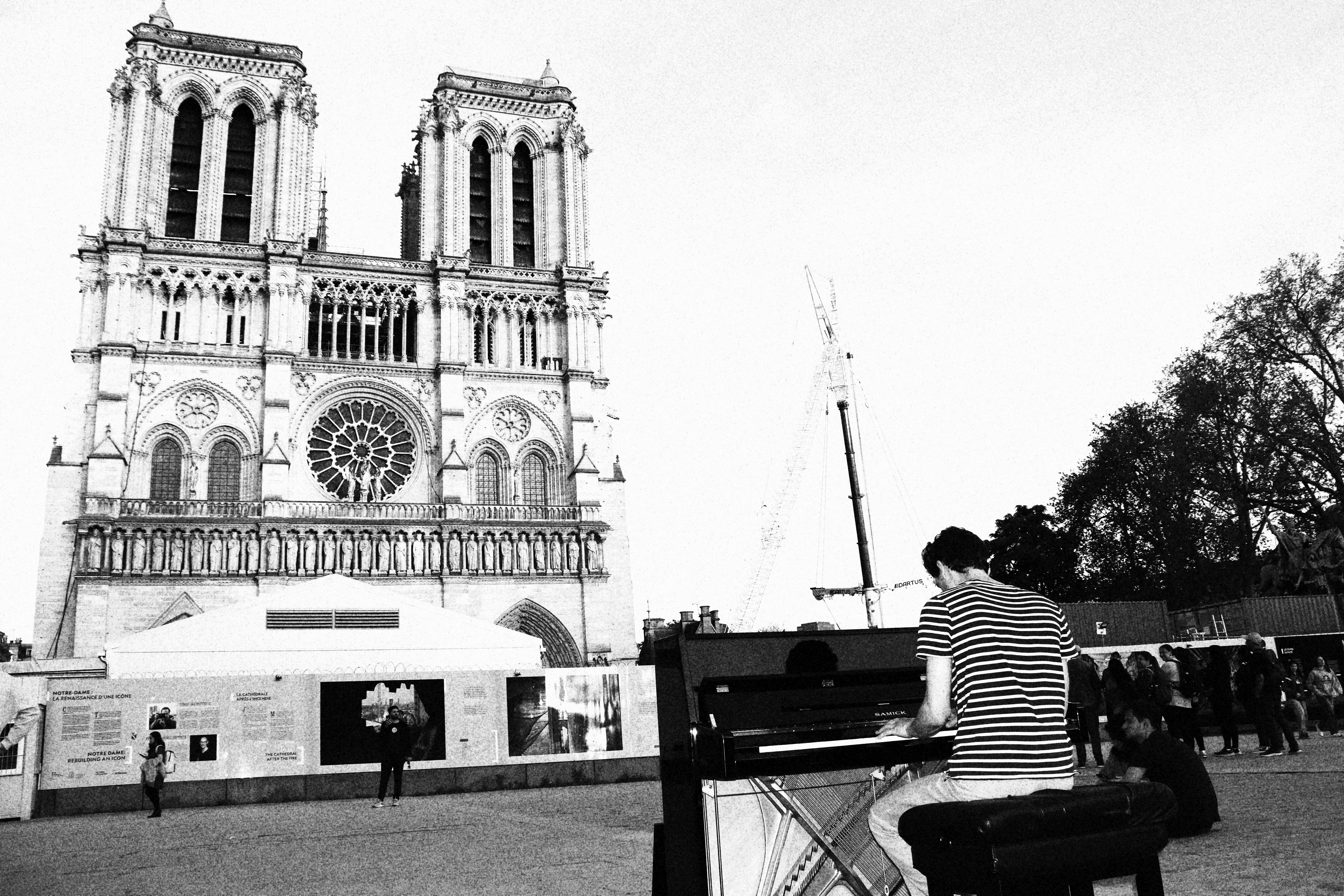 Pianista toca fora da catedral de Notre Dame, Paris.