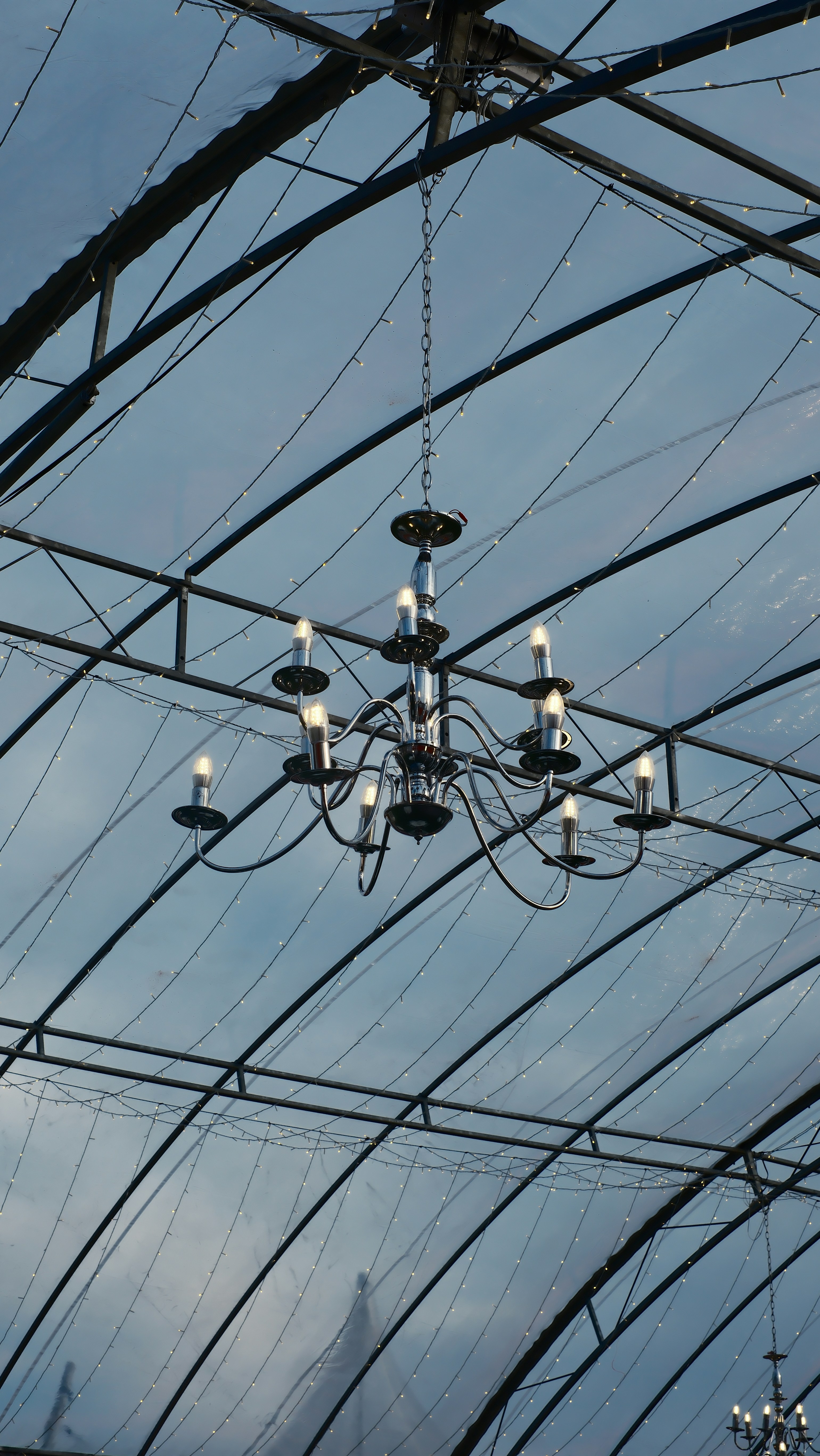 A chandelier hangs from a metal structure.