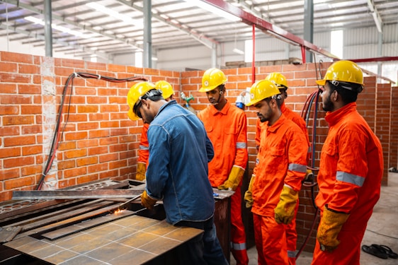 Workers in hard hats and safety vests in a workshop