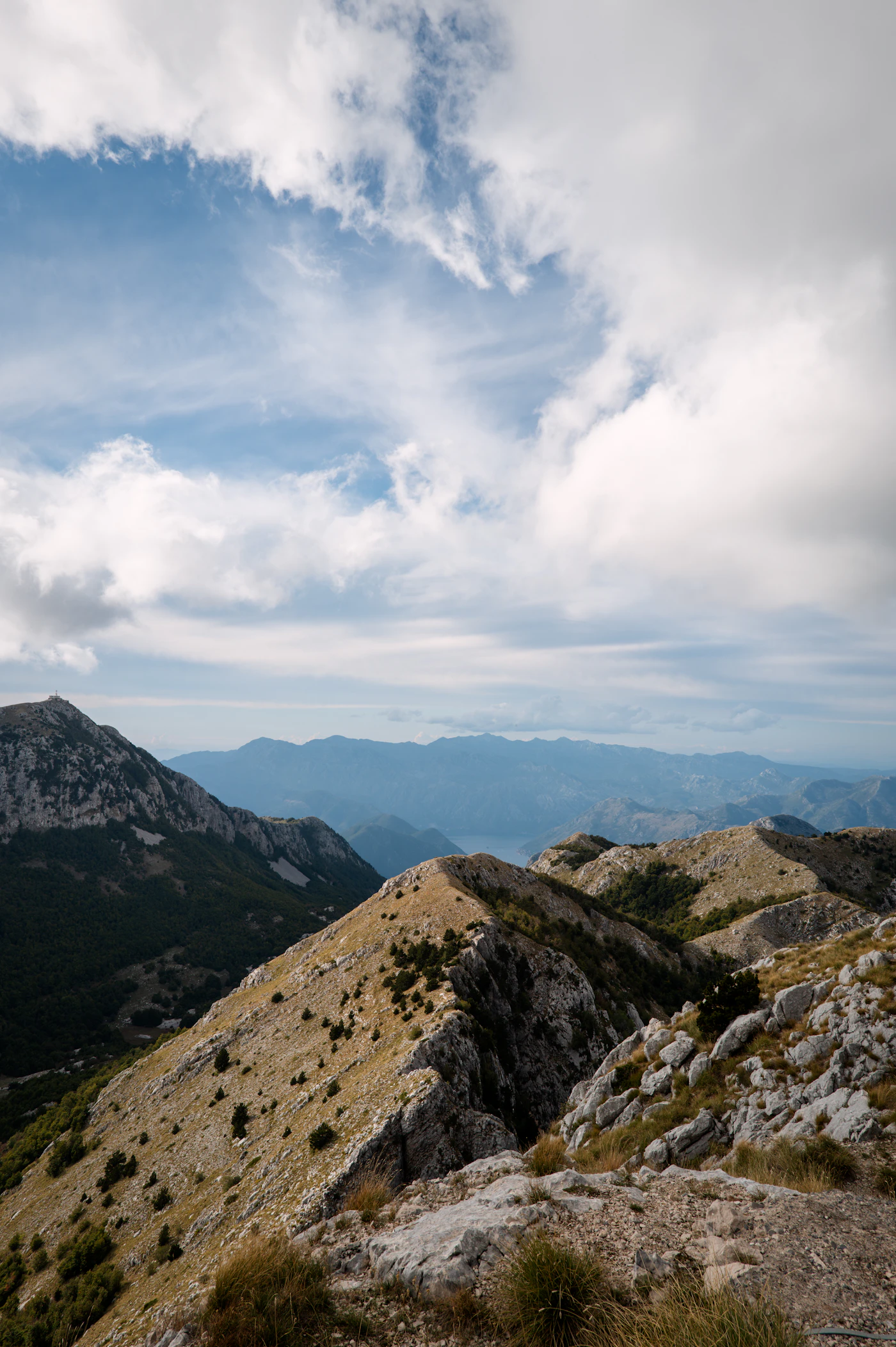 A rocky mountain ridge under a cloudy blue sky