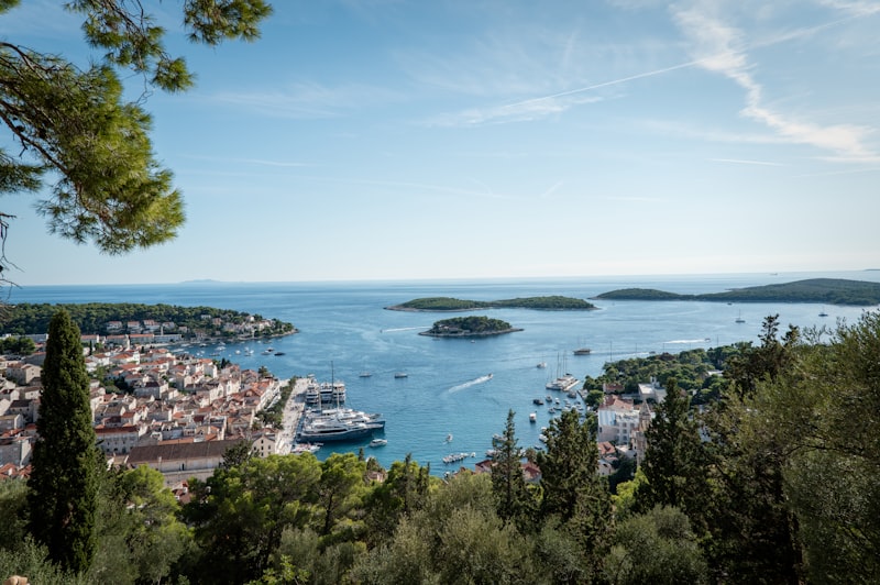 Coastal town with harbor and islands under blue sky