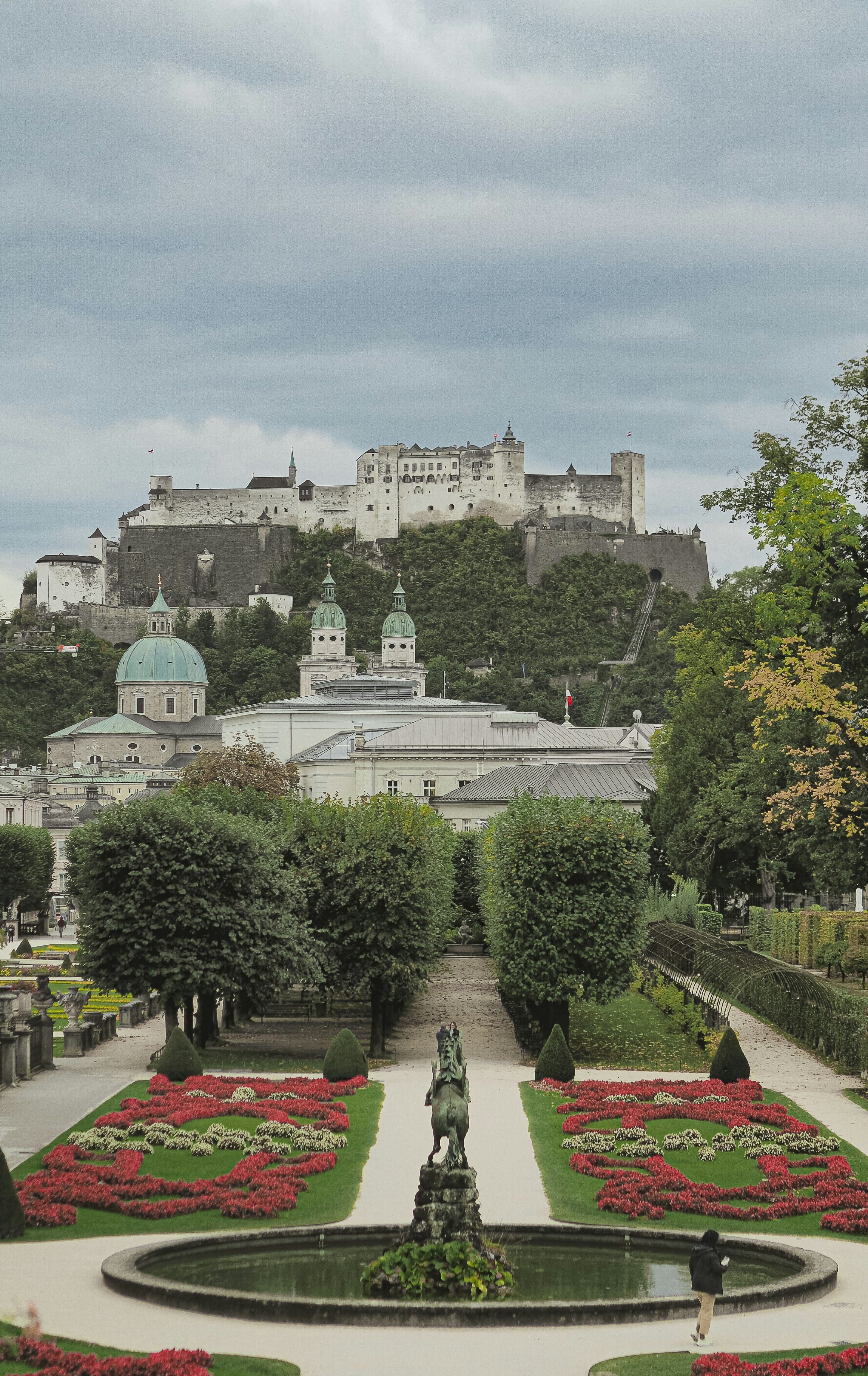 Baroque garden with fountain and castle on hill