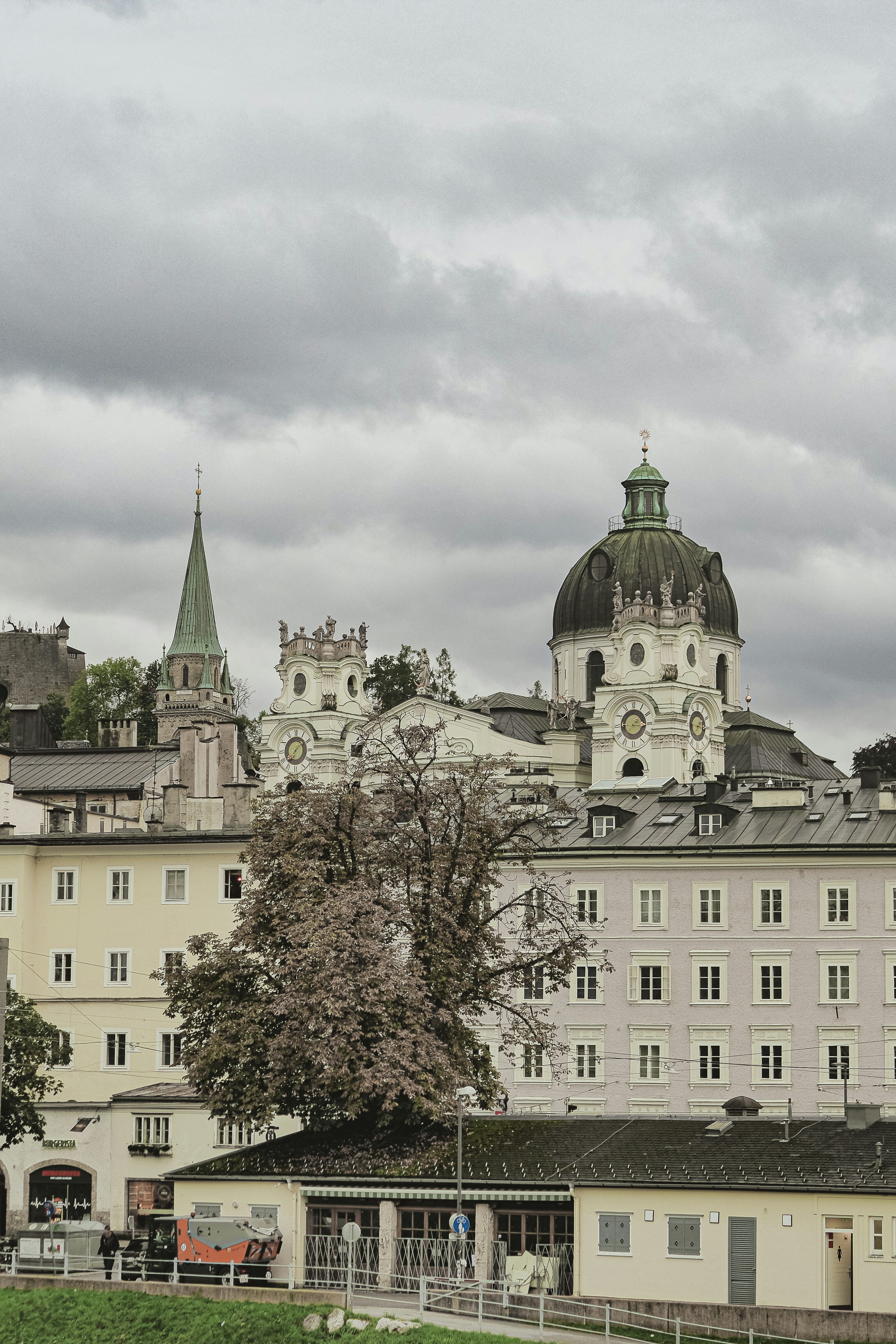 Historic buildings and church spires under cloudy sky.