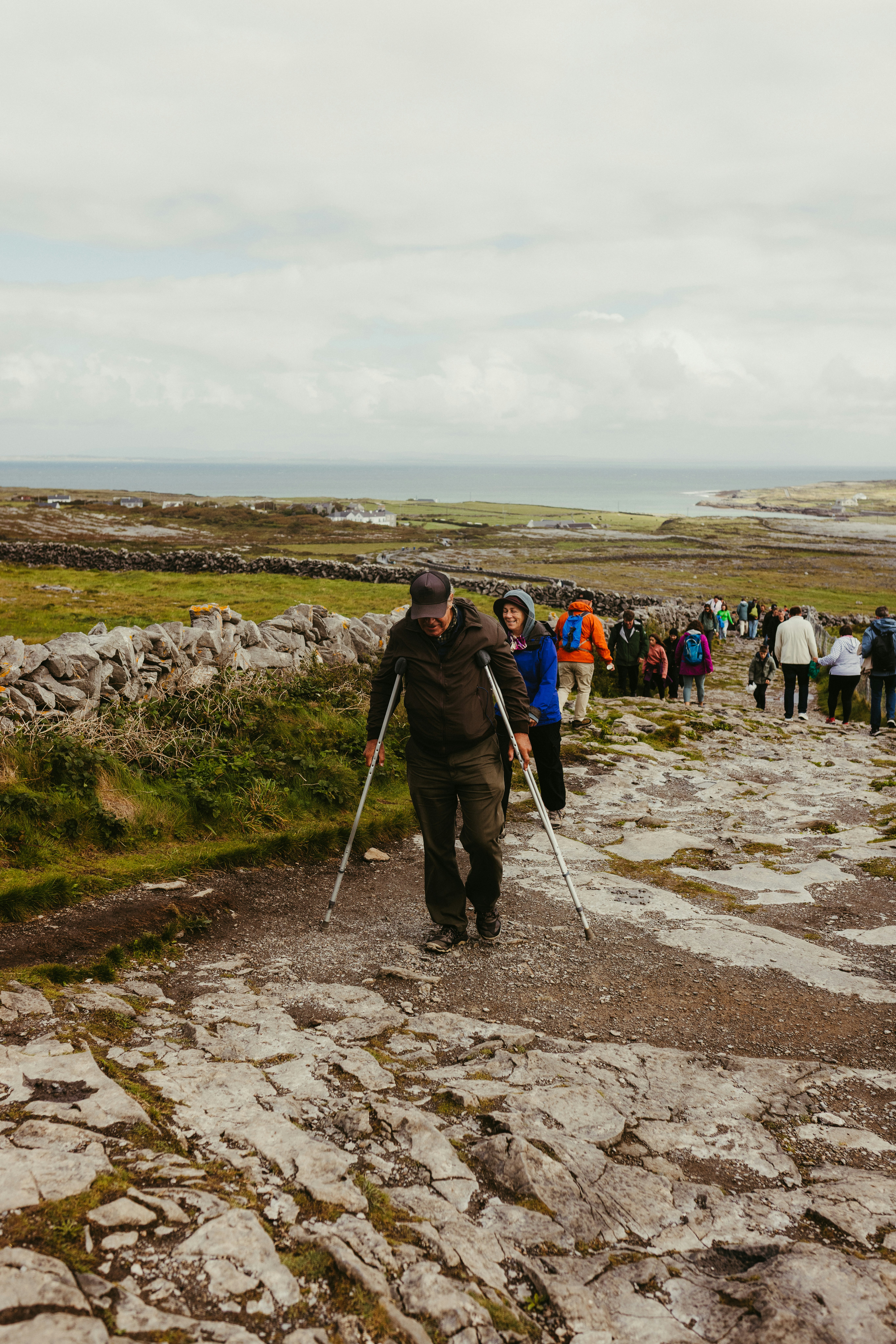 A group of people walking on a rocky path outdoors.