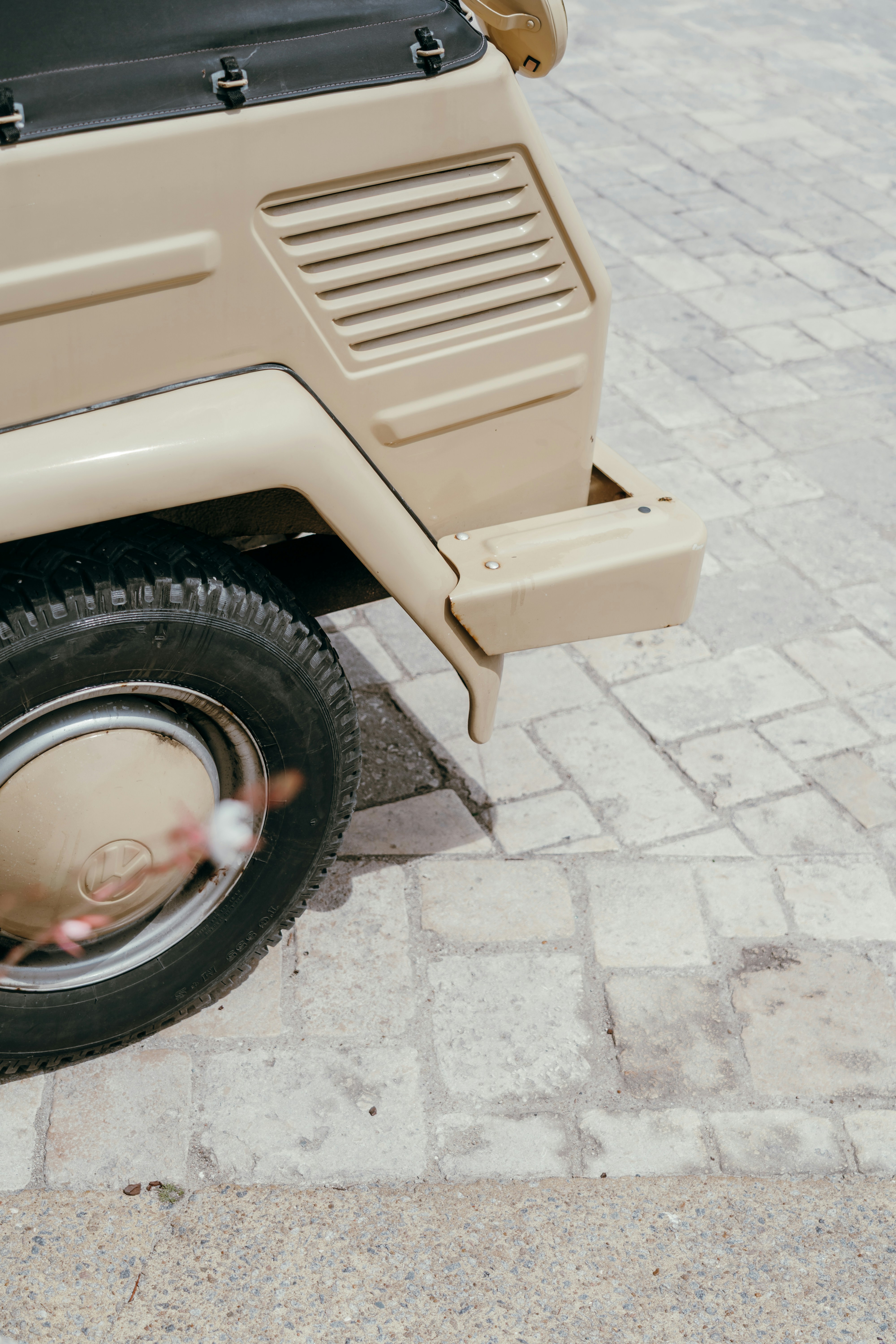 Close-up of a vintage beige car tire and fender.