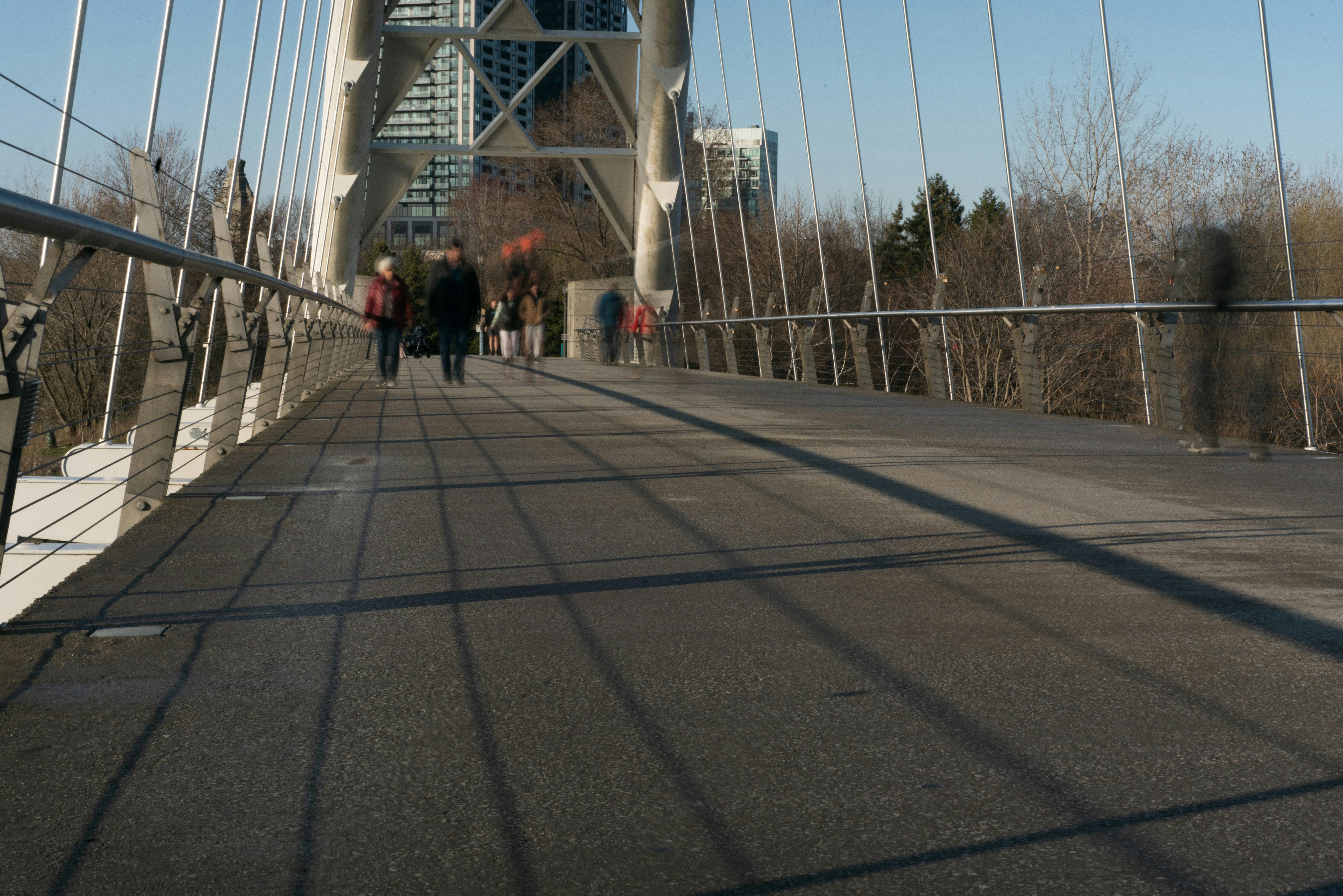People walking on a pedestrian bridge in winter.