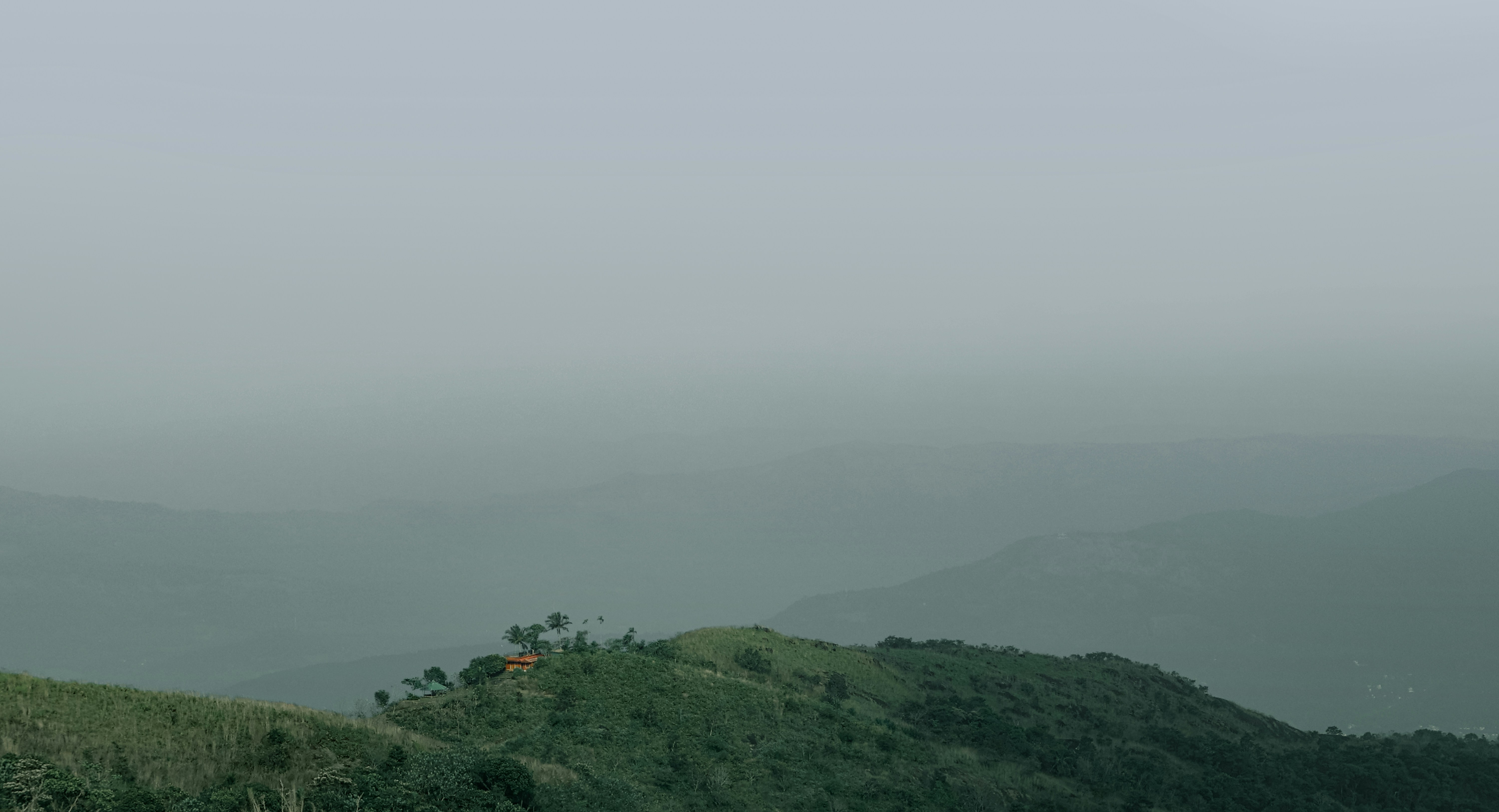 Misty mountain range with green trees and hills