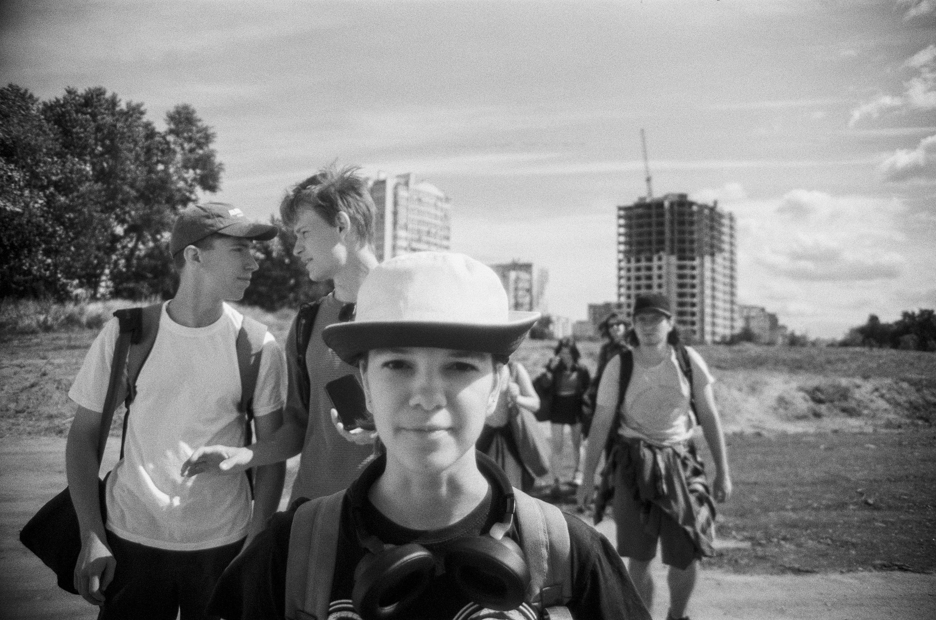 Group of young people walking outdoors with backpacks.